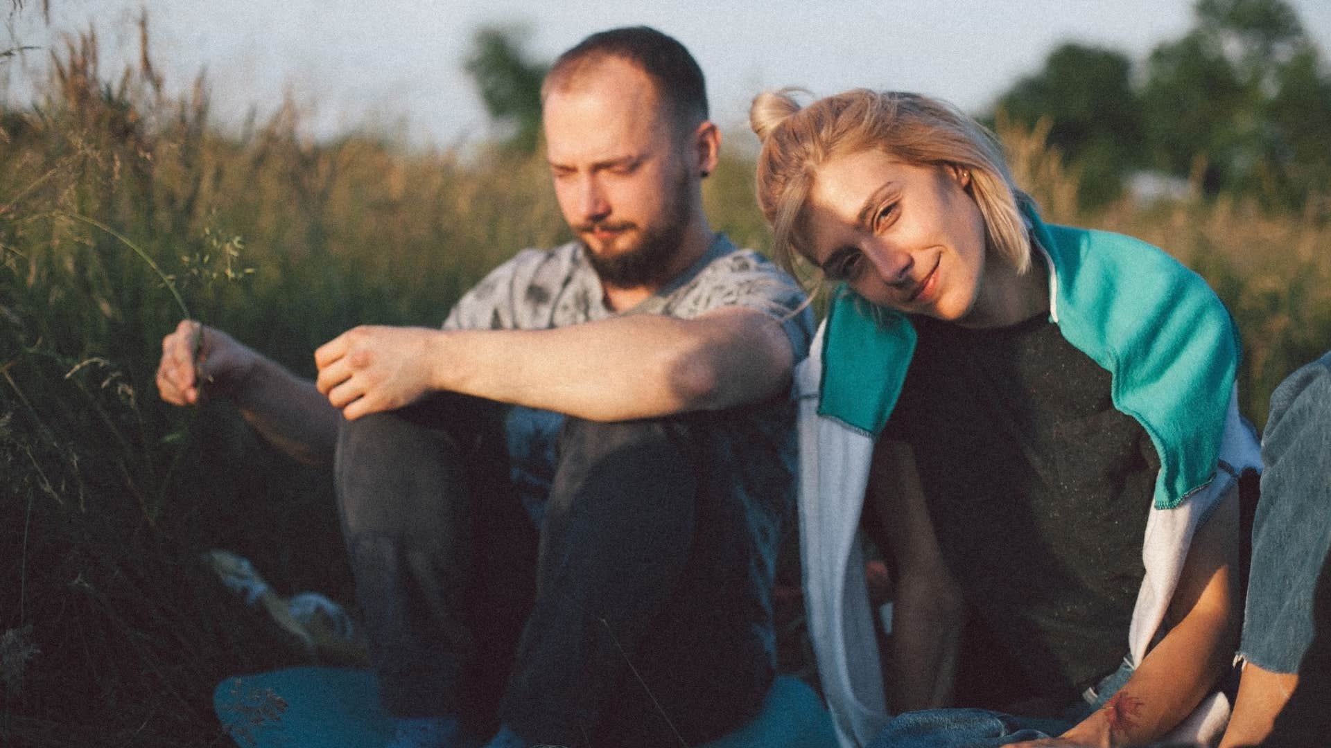 casual couple sitting in a field