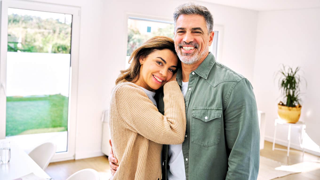 Mature couple in relationship posing in house.