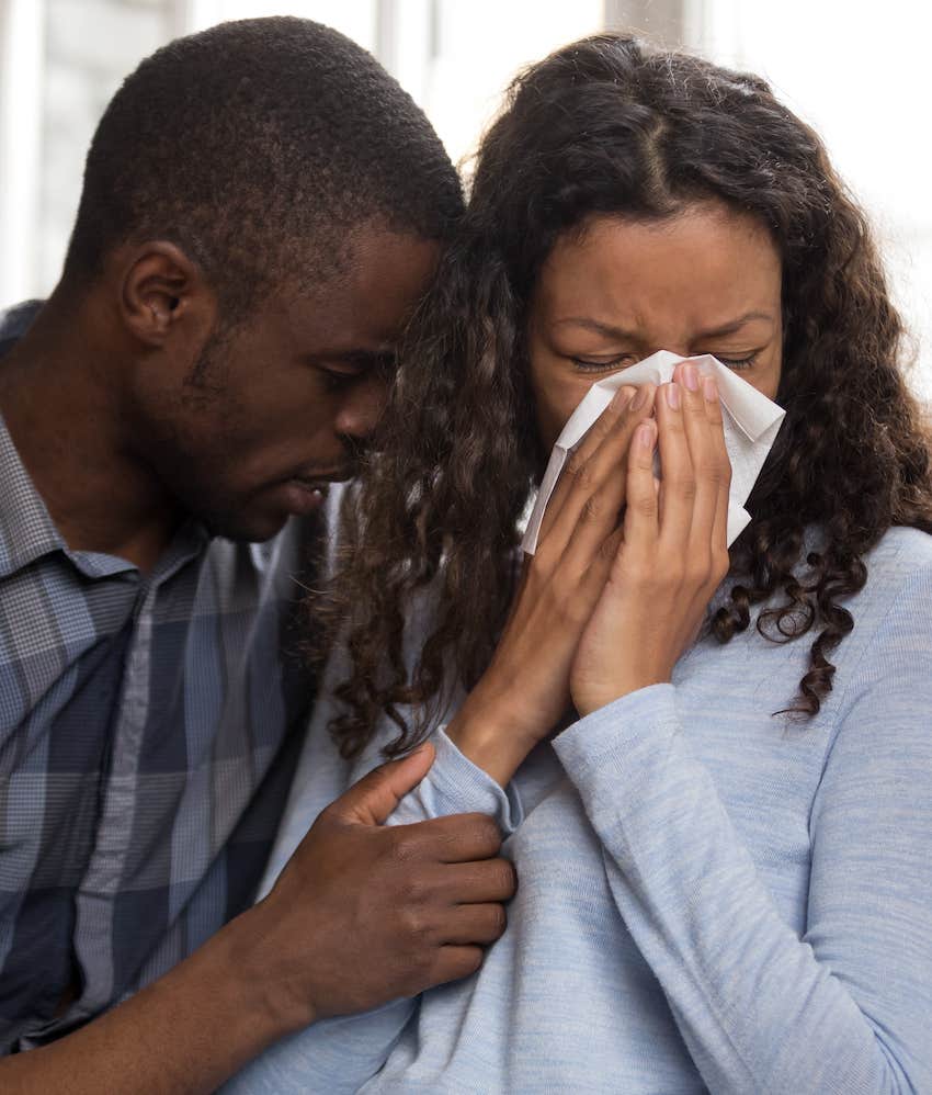 Woman cries while man holds her emotionally