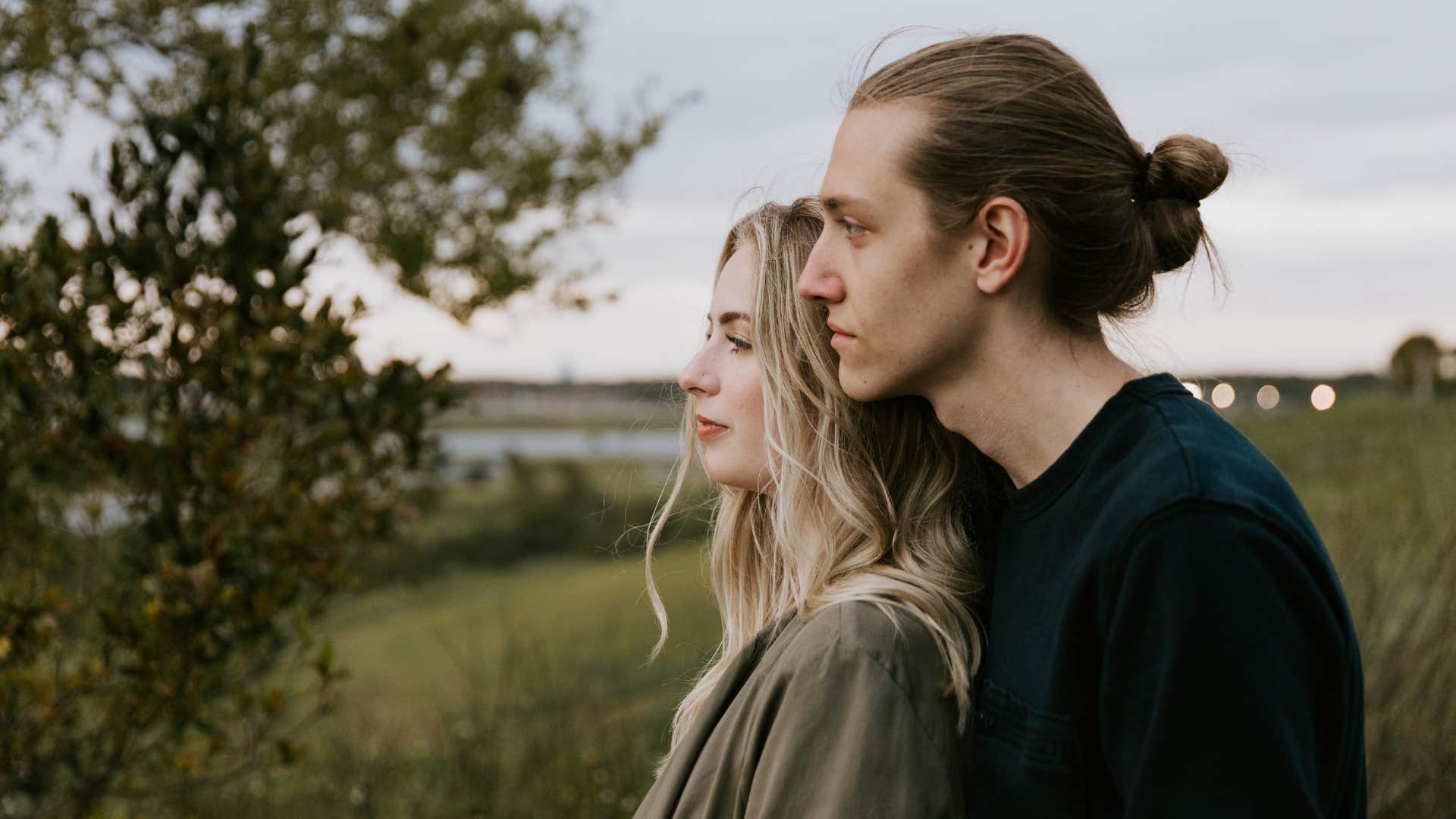 couple looking out onto a lake side by side