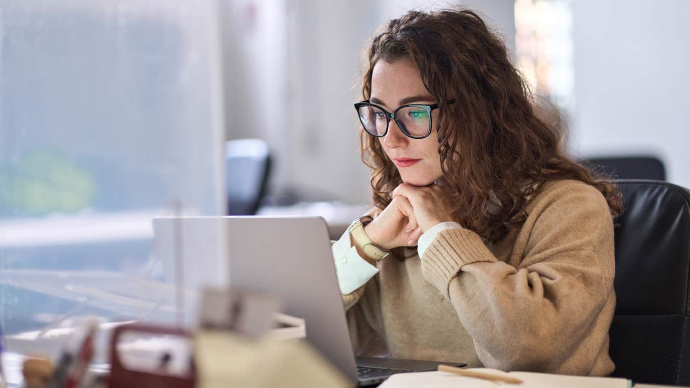 serious employee watching laptop in office