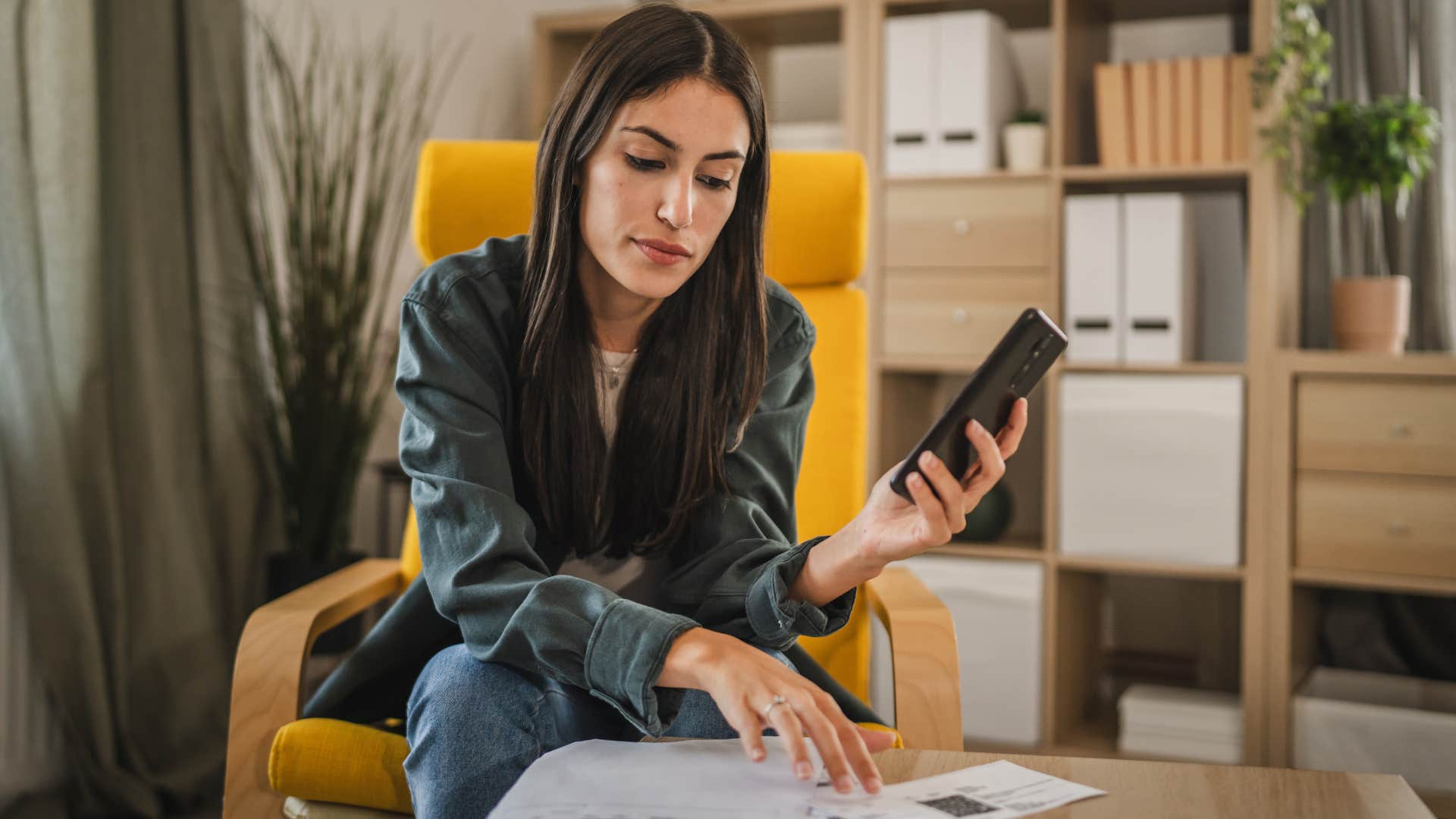 Woman looking stressed paying her bills.