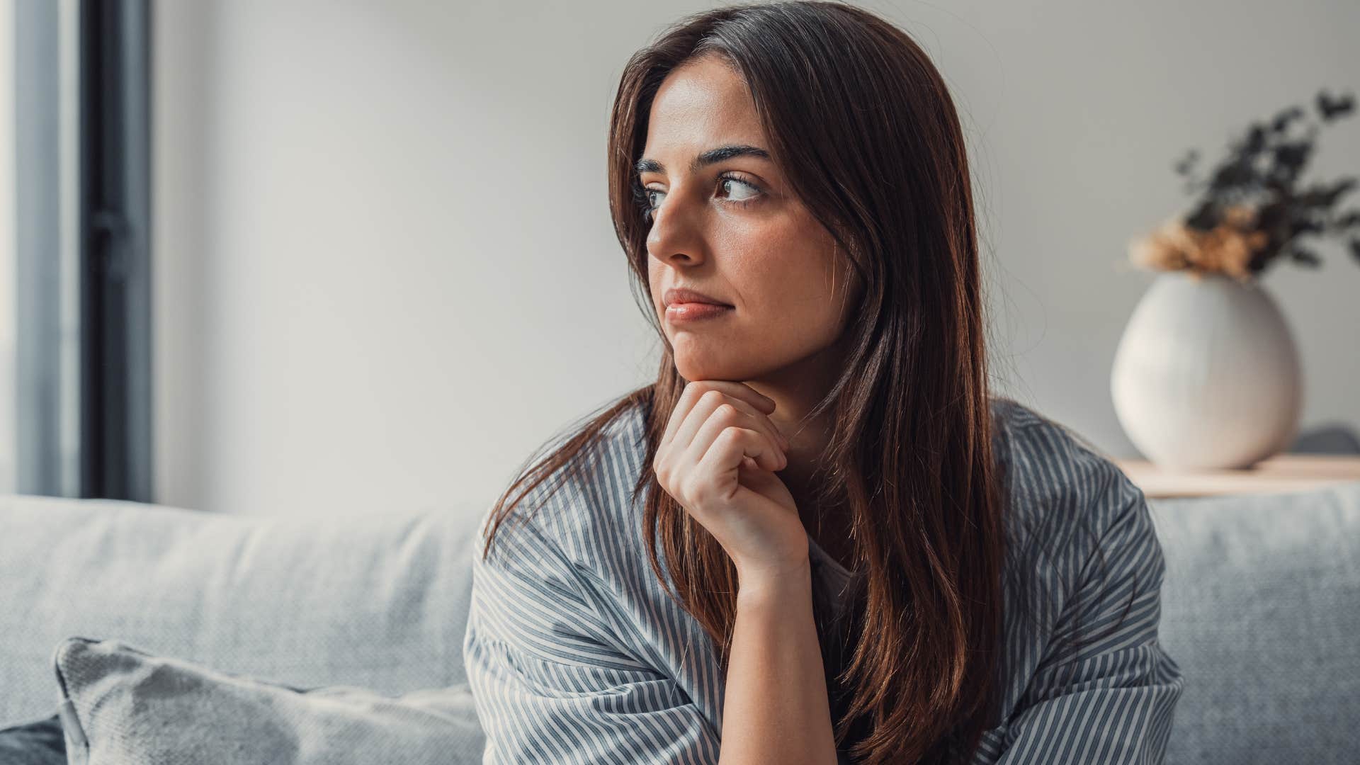 Woman looking sad staring out a window