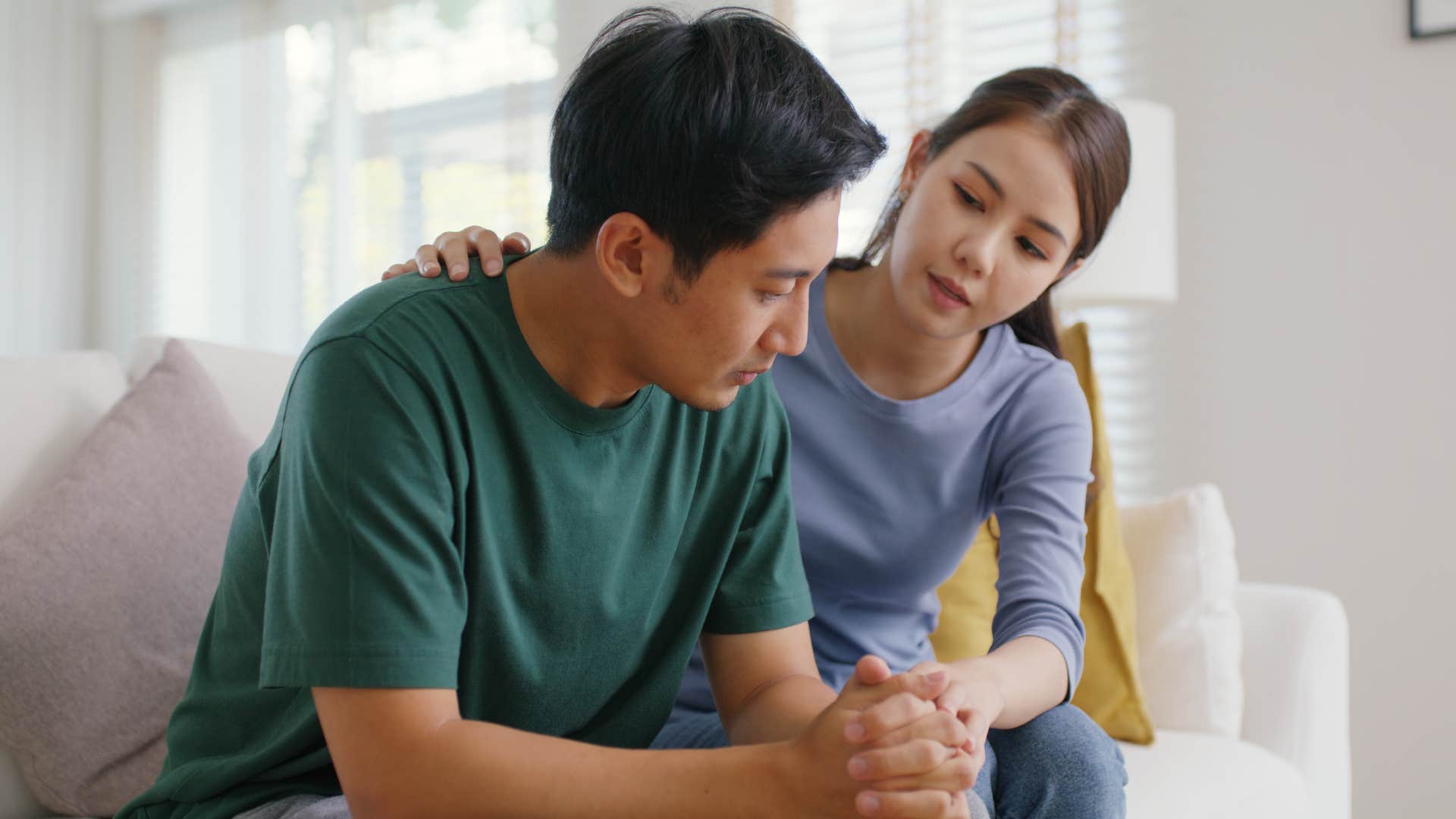 Woman comforting her partner on the couch.