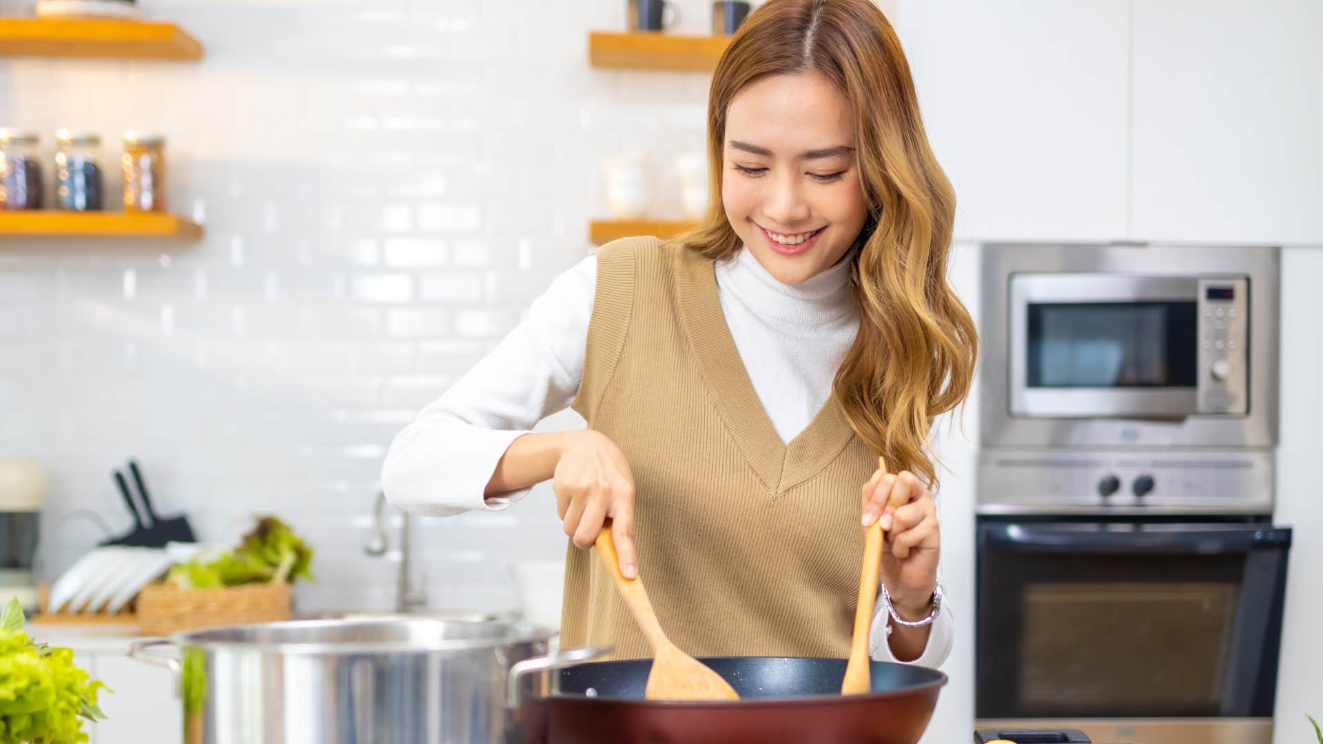 Woman smiling while cooking in her kitchen