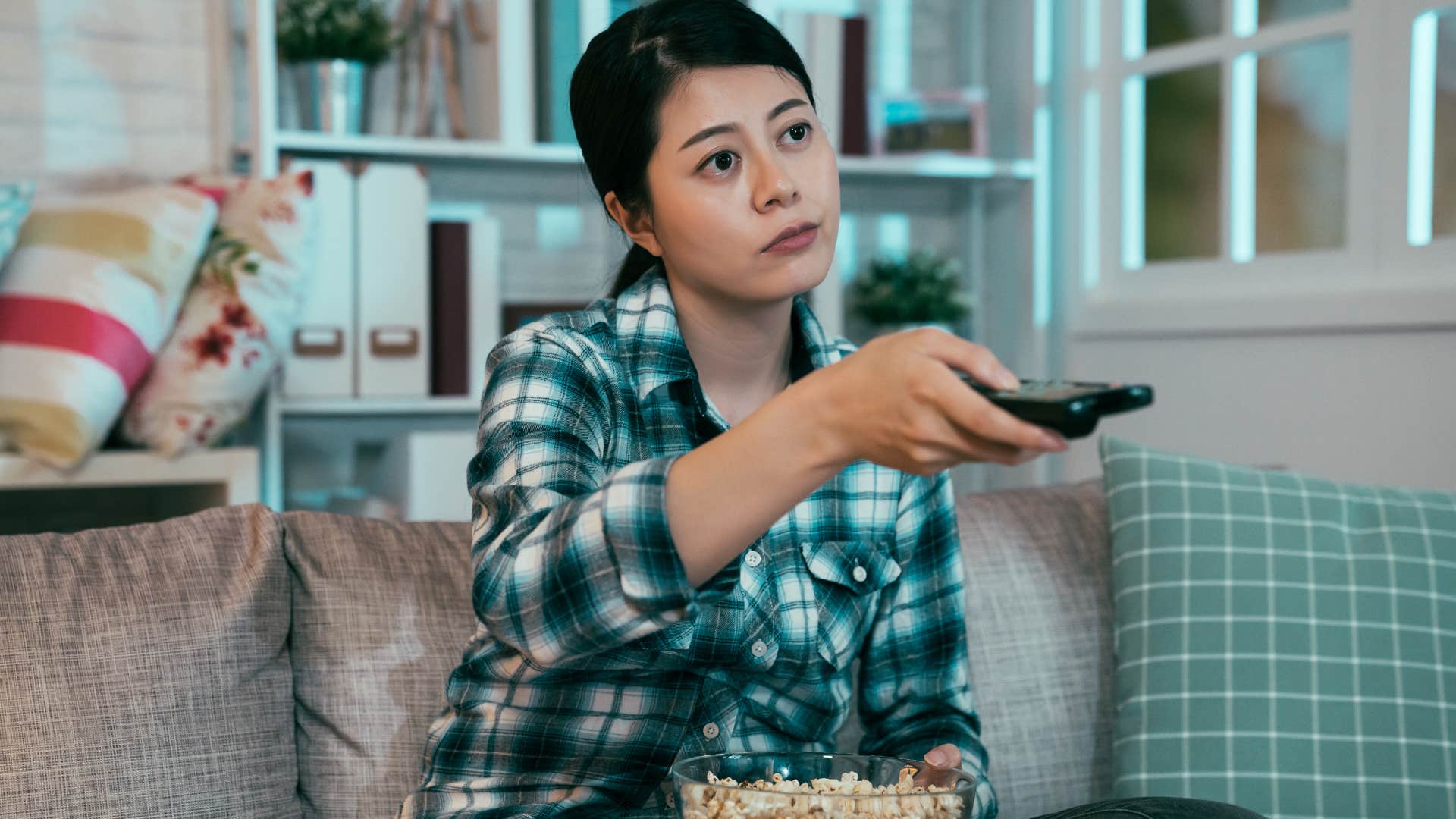 Woman looking annoyed while watching TV