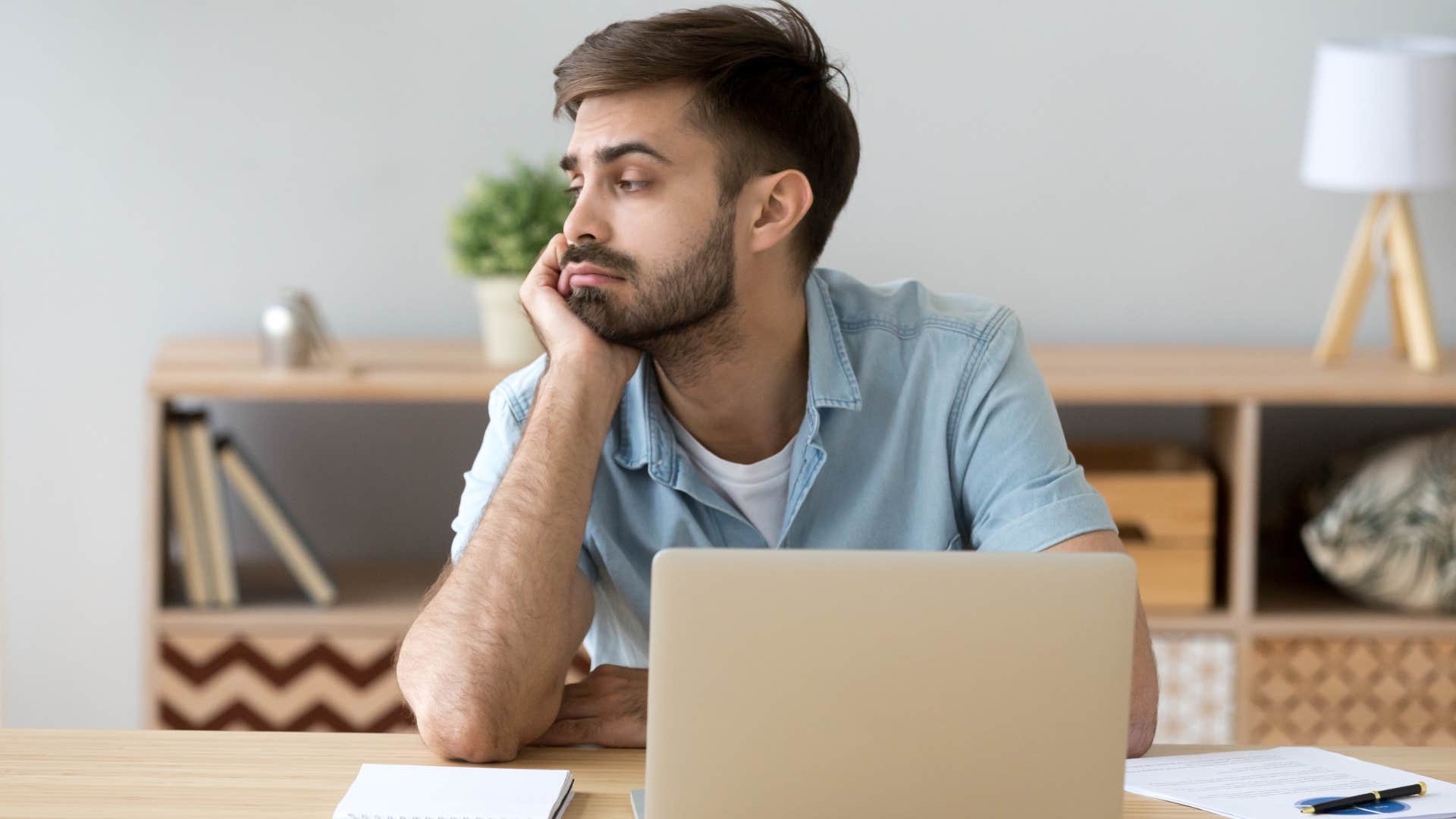 Young man looking annoyed on his laptop