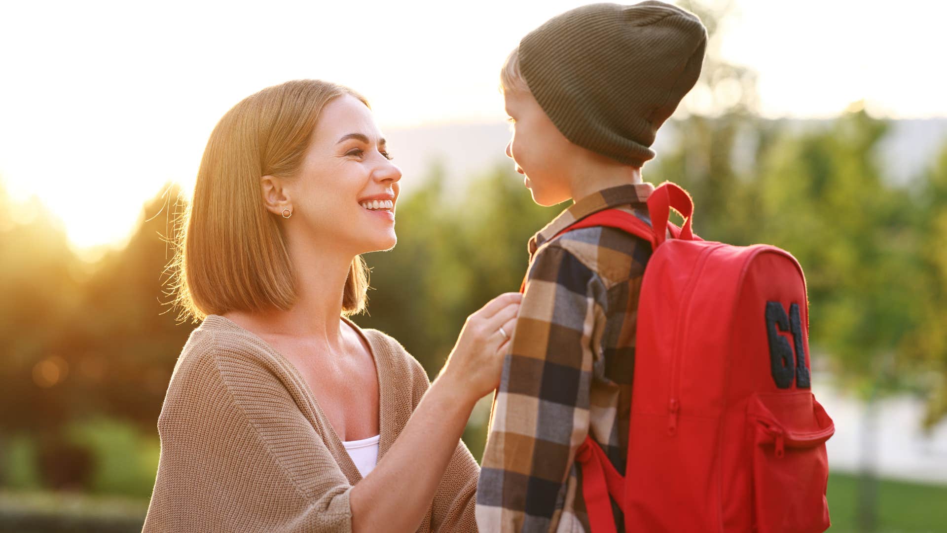 Woman fixing her young son's coat before school