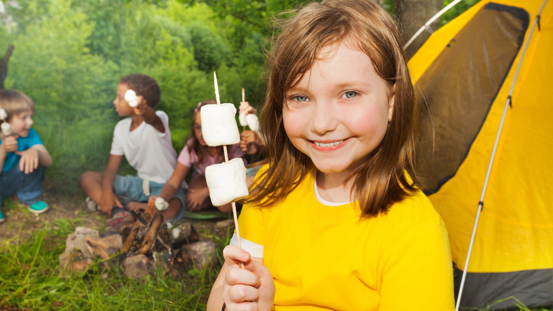 Young girl roasting marshmallows at summer camp