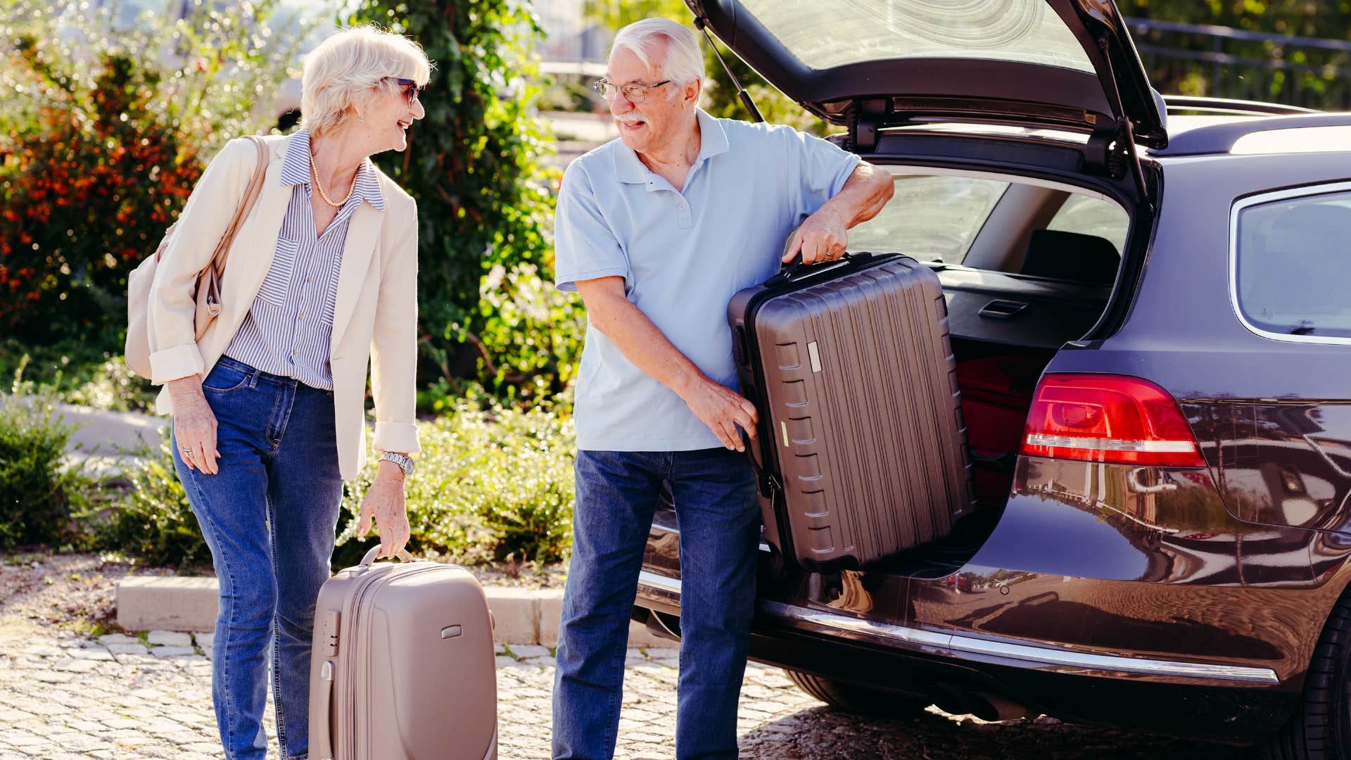 Older couple packing their suitcases in the car