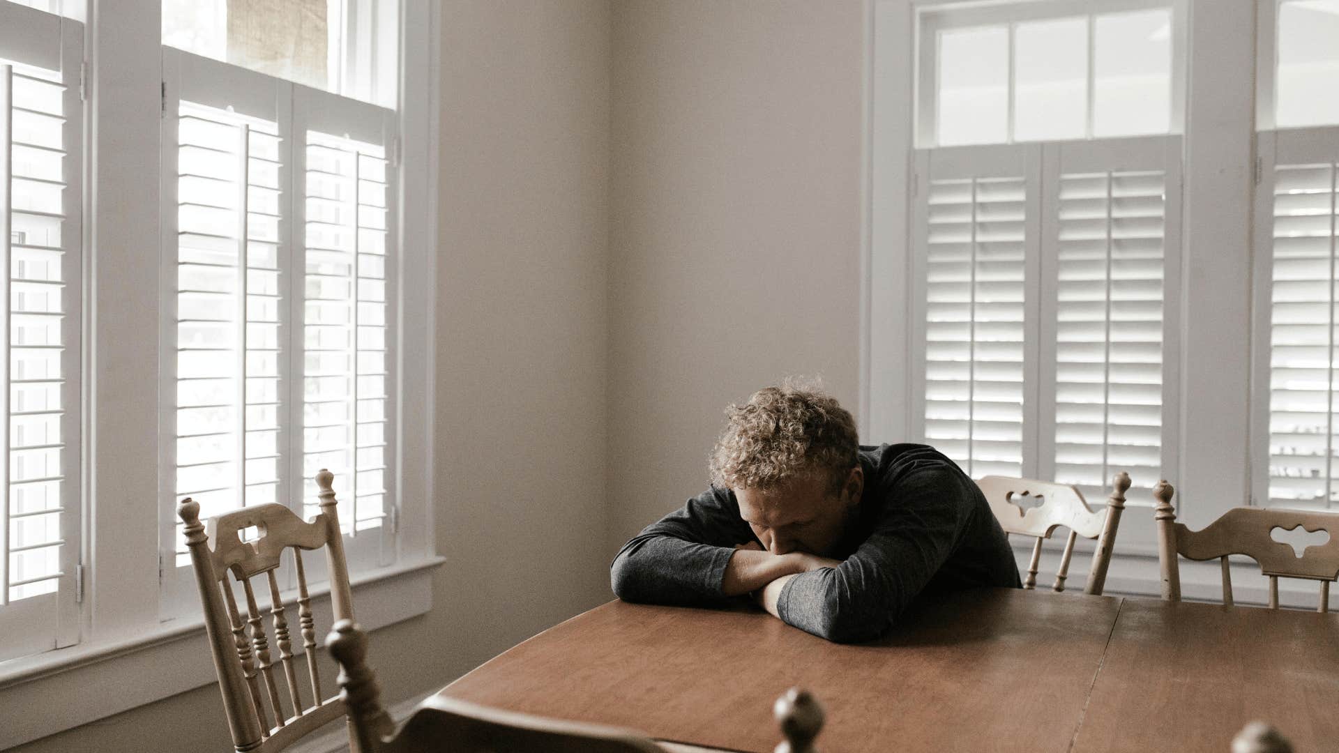 upset man sitting at table