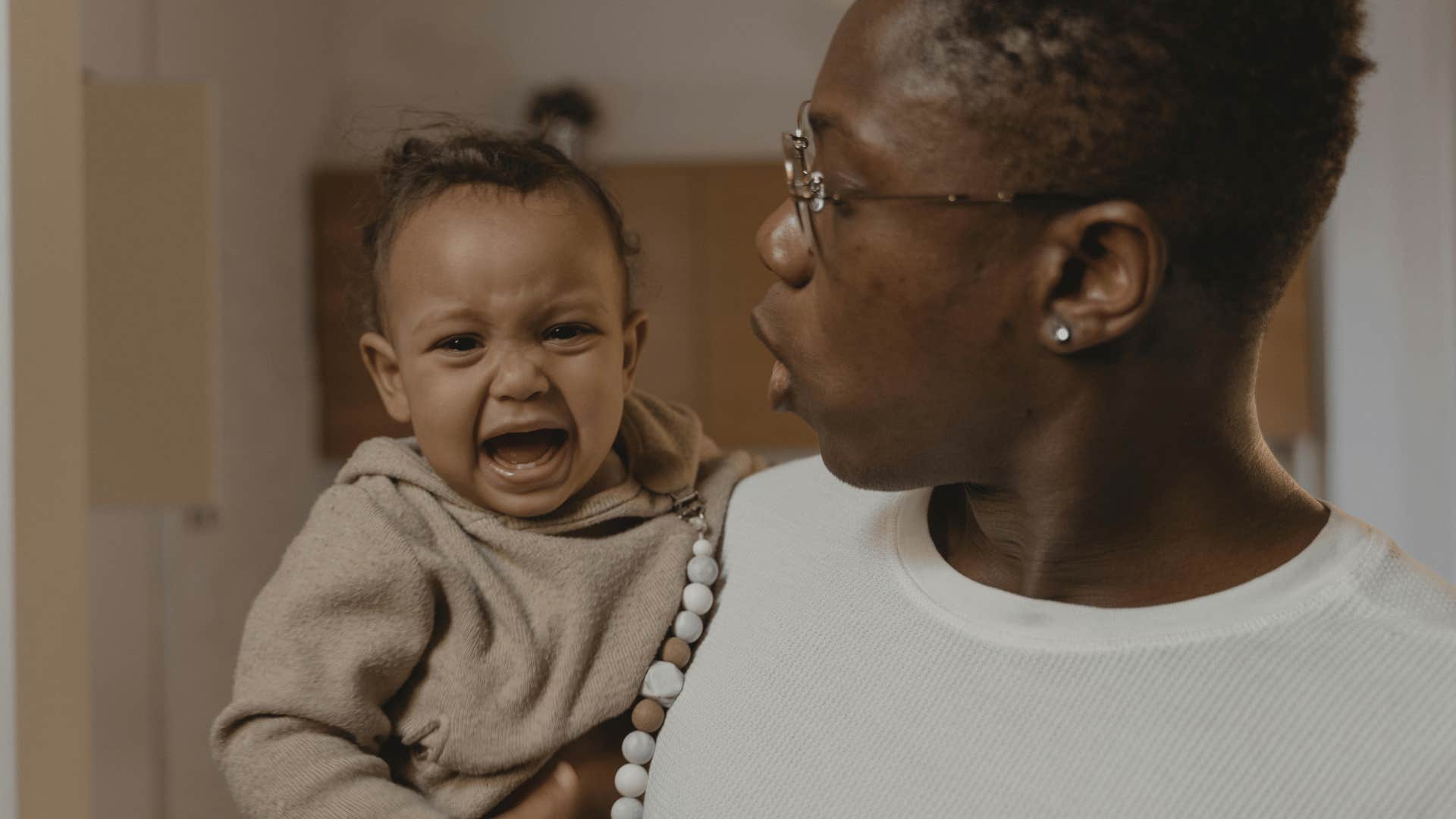 man holding crying baby