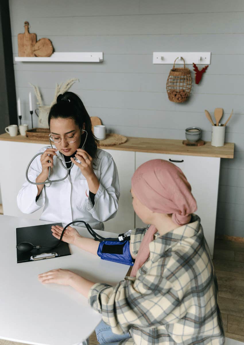 female doctor measuring young woman's blood pressure