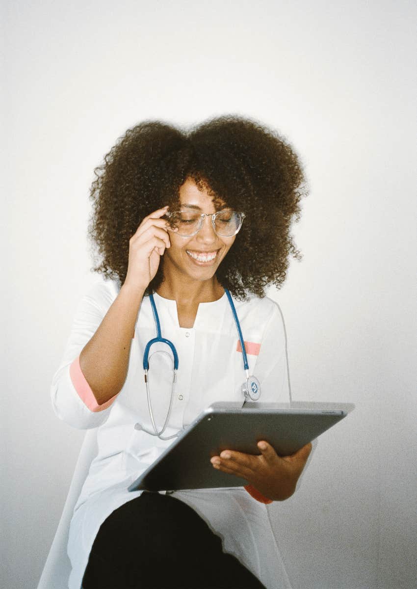 female doctor smiling down at a clipboard