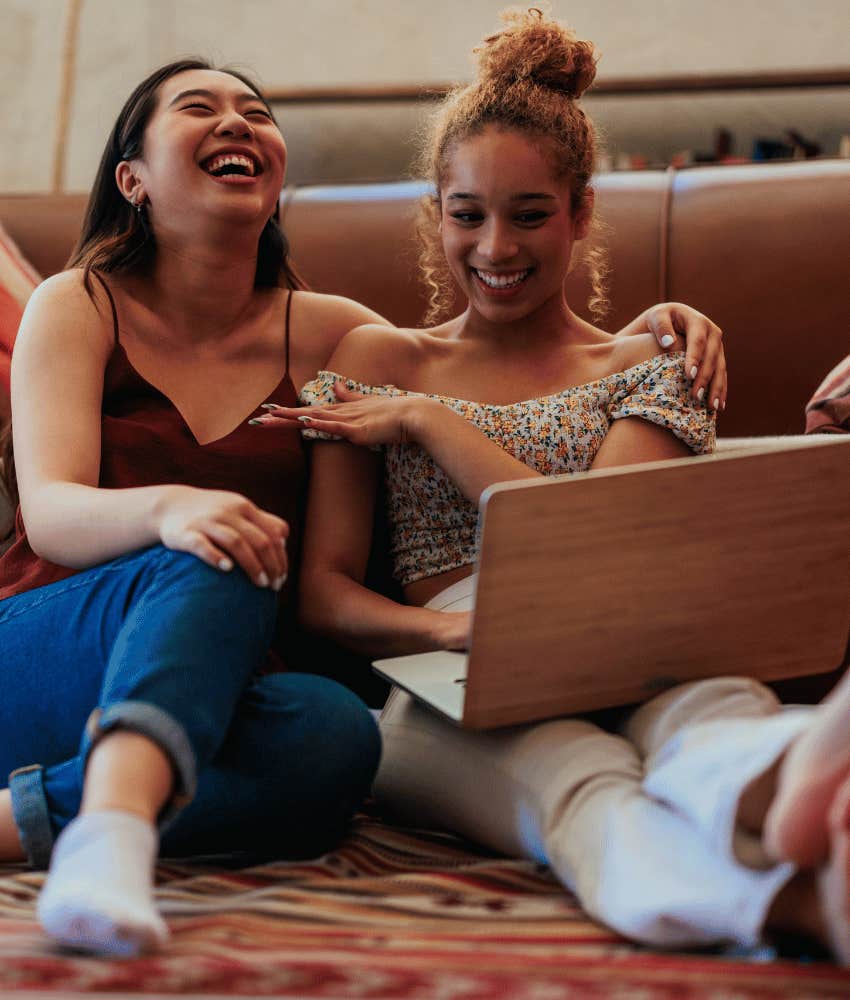 Couple laugh while while using laptop to explore shared interest