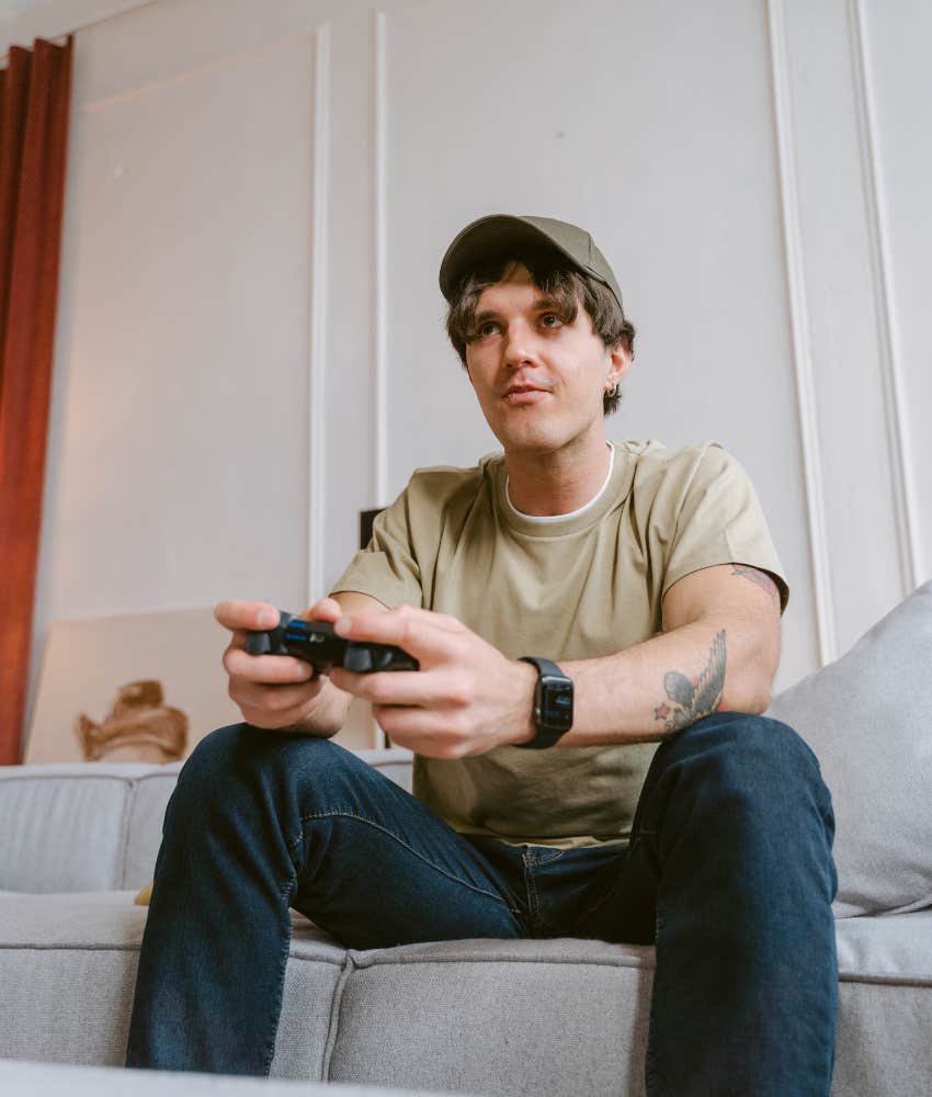 man playing video games while sitting on a couch