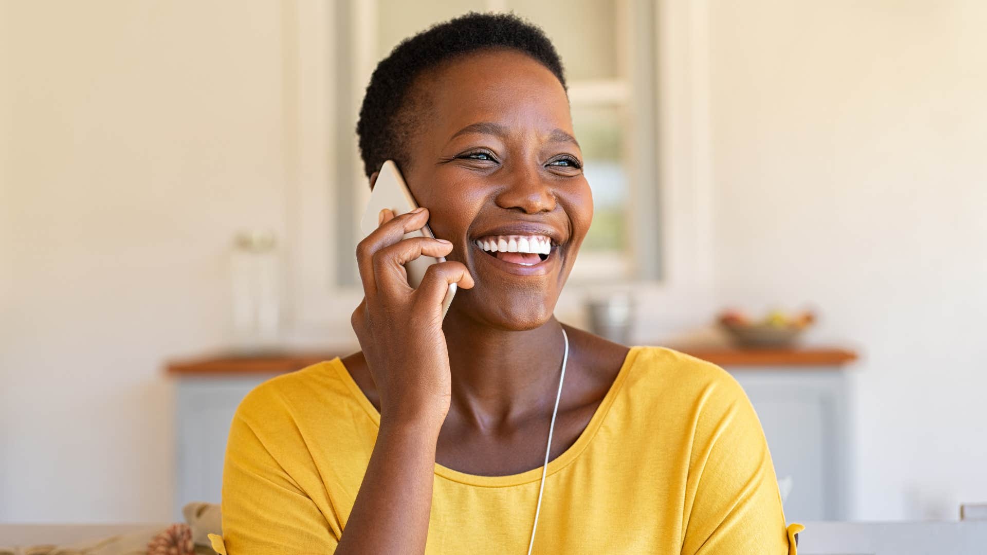 Gen X woman smiling and talking on the phone.