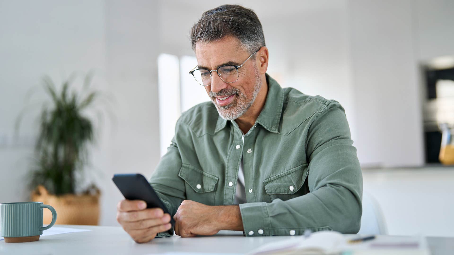 Gen X man scrolling on his cell phone.