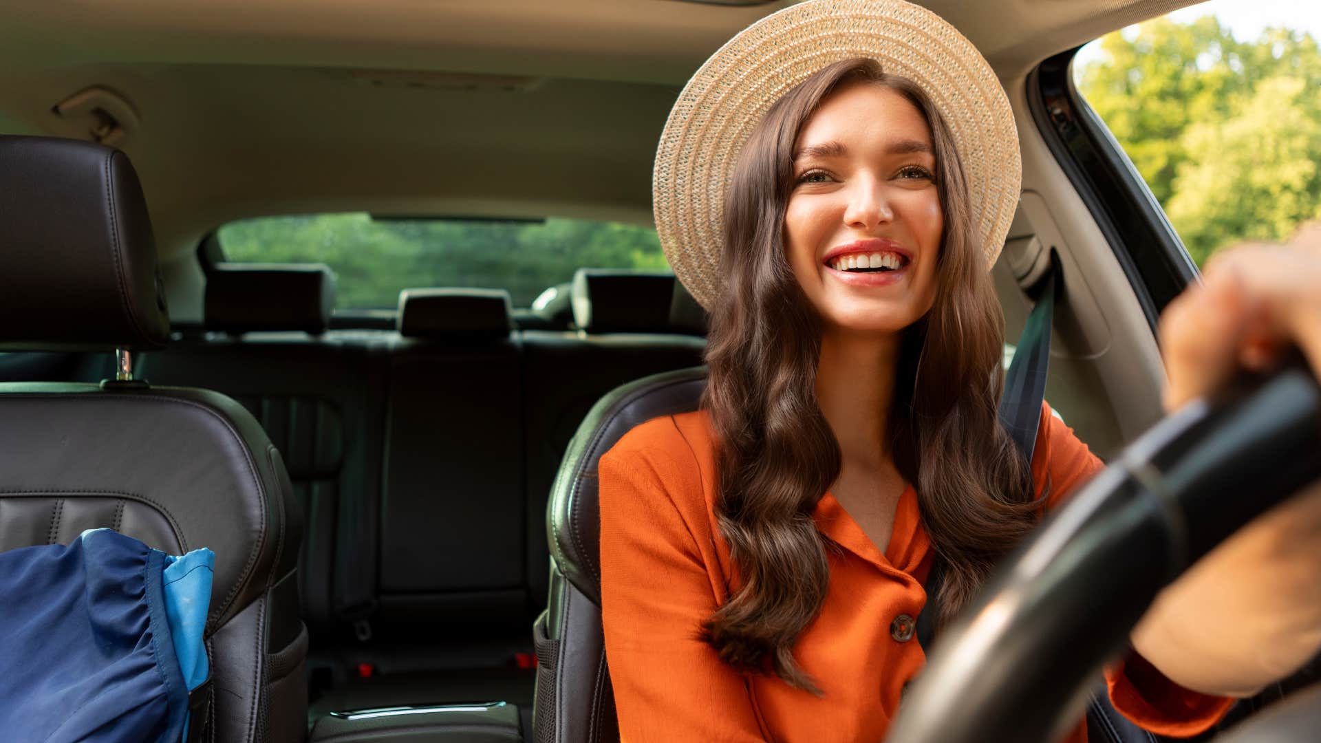 Gen X woman smiling and driving her car.