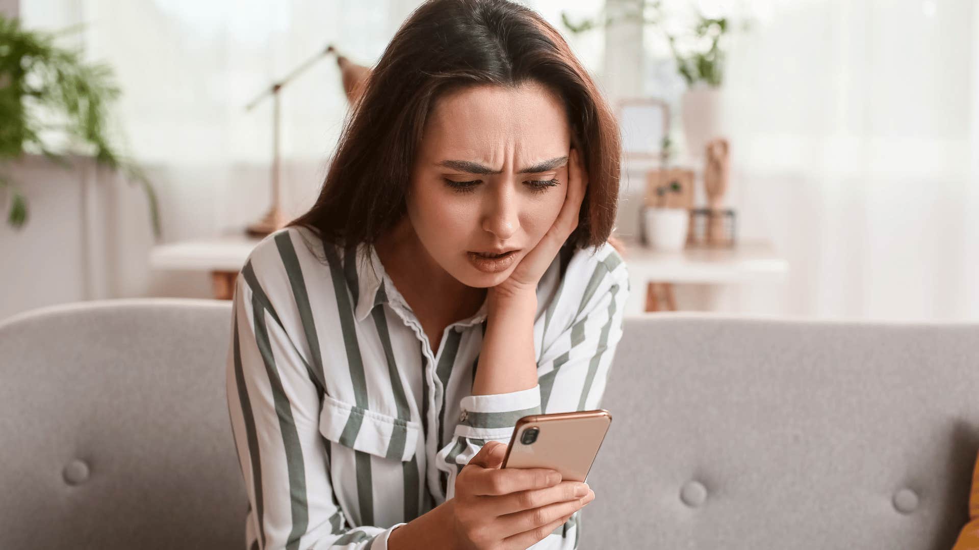 woman staring at phone distressed 