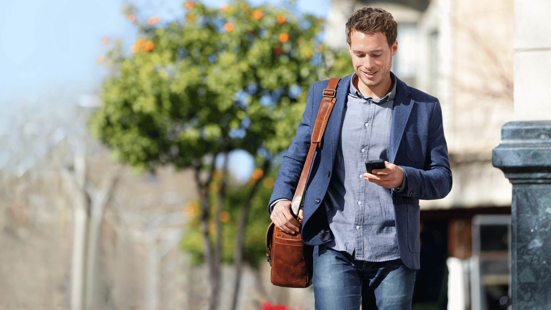 man walking while staring at phone 