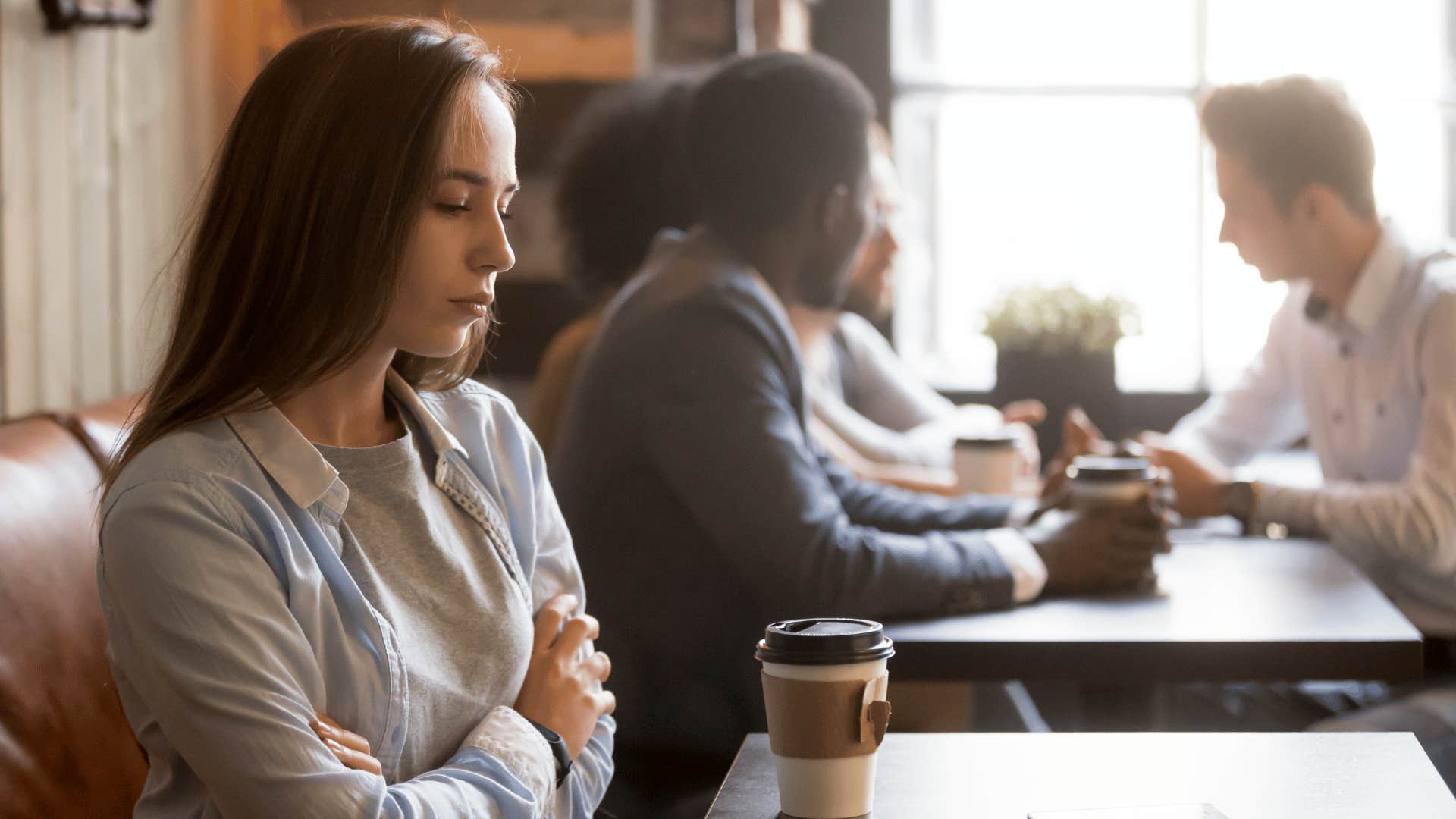 woman staring at table sitting alone 