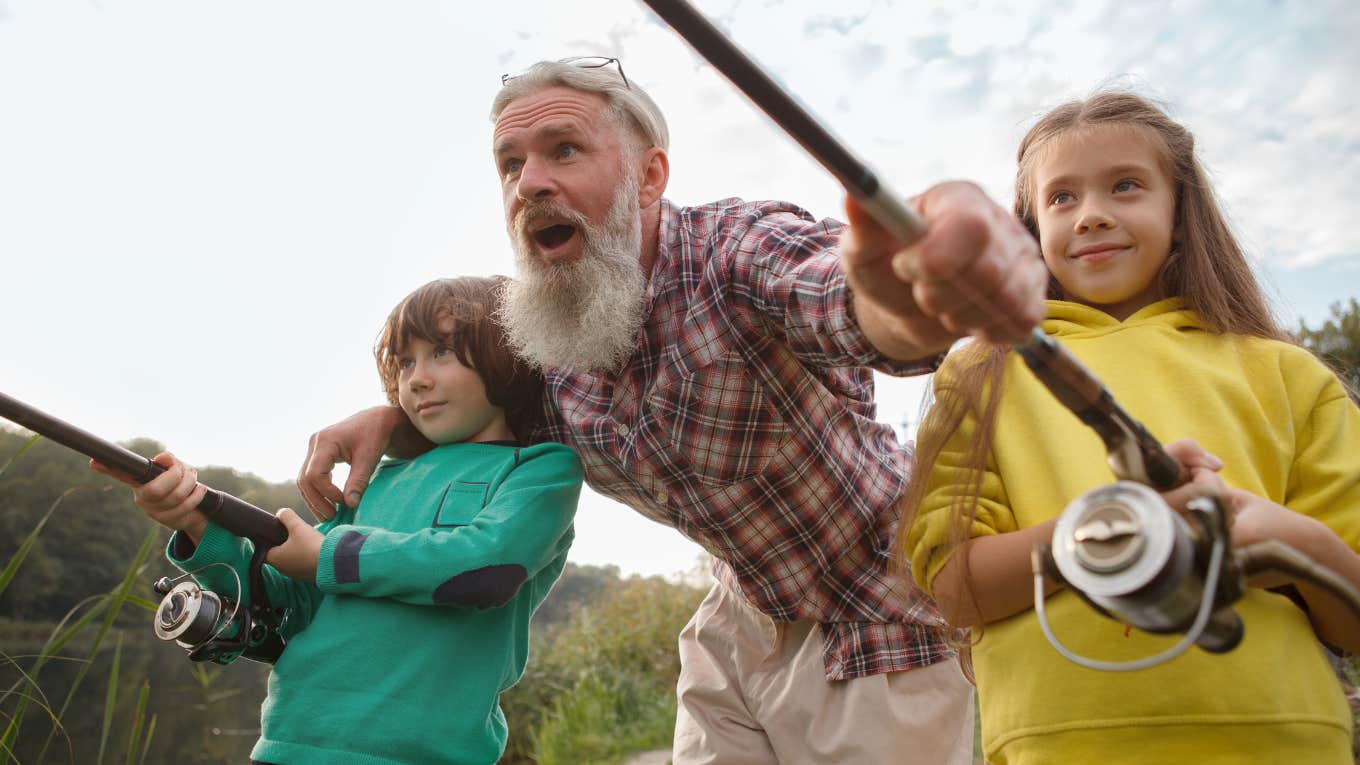 Low angle shot of senior fisherman and his grandkids fishing together