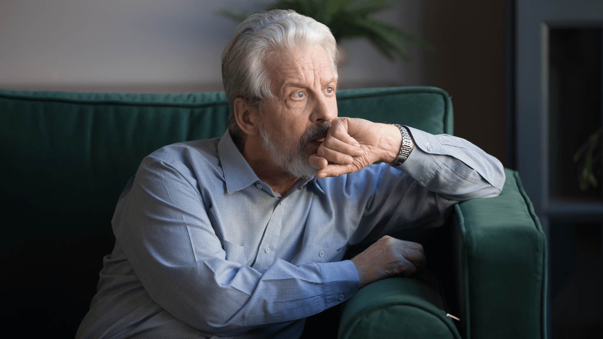 grandfather sitting on couch and looking out window