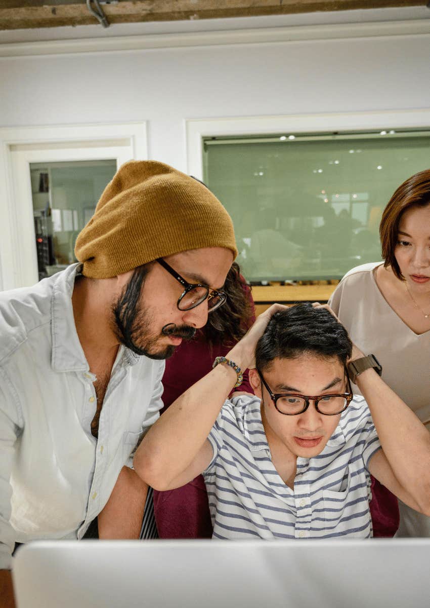 group looking at a computer in shock