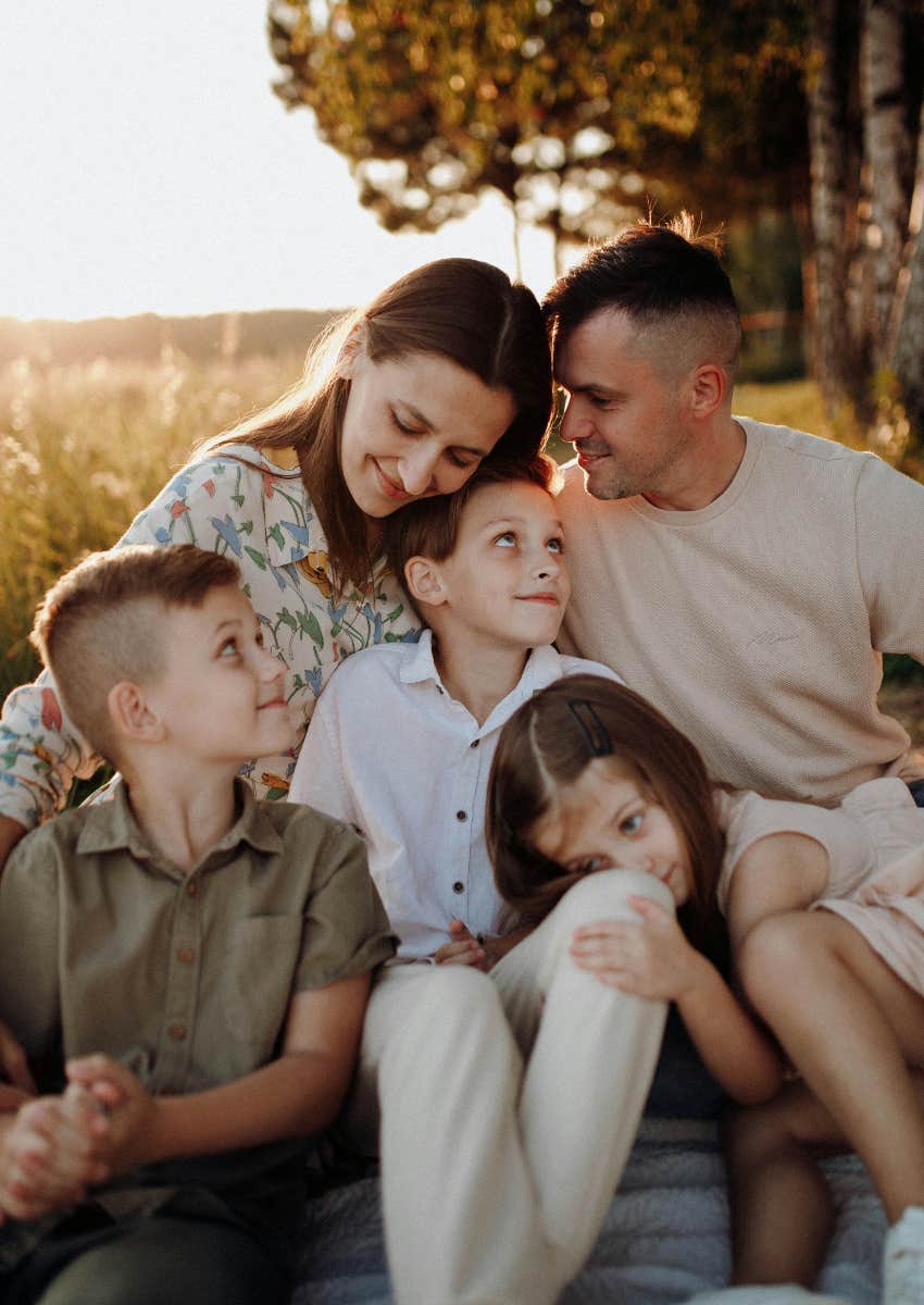 portrait of parents and three kids smiling at each other