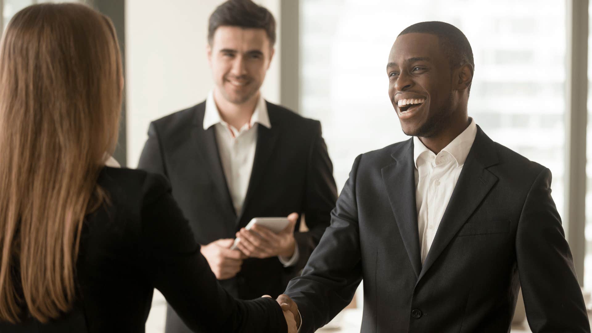 man shaking woman's hand