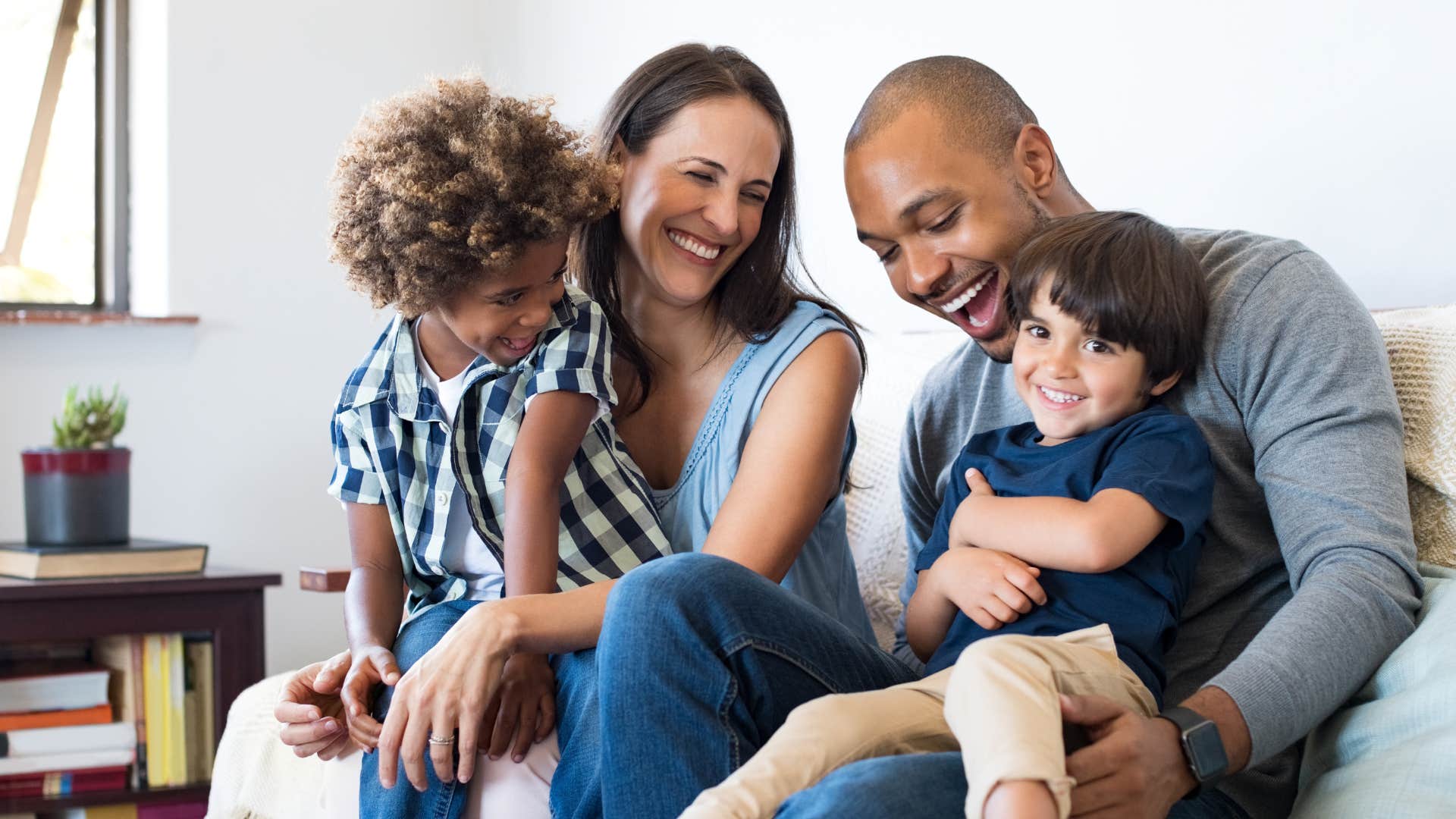 Family smiling and sitting on the couch together.