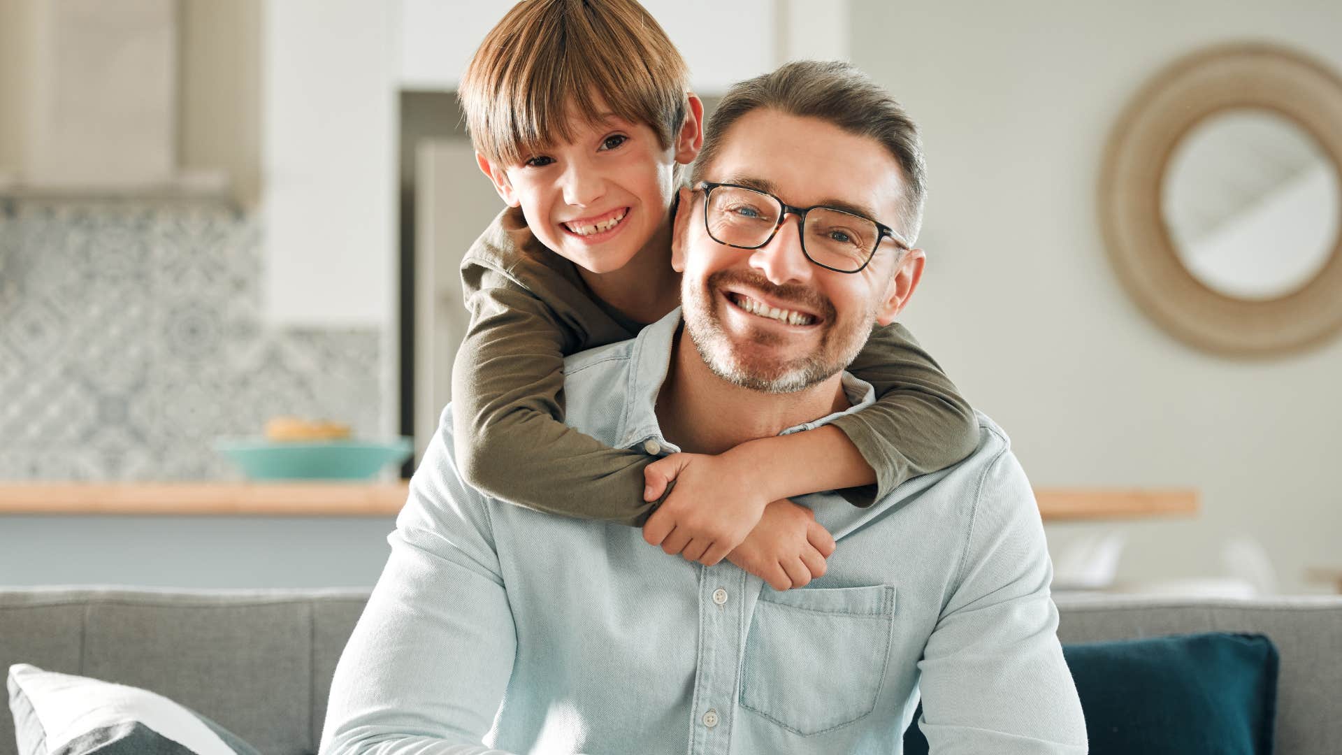 Son hugging his dad on the couch.