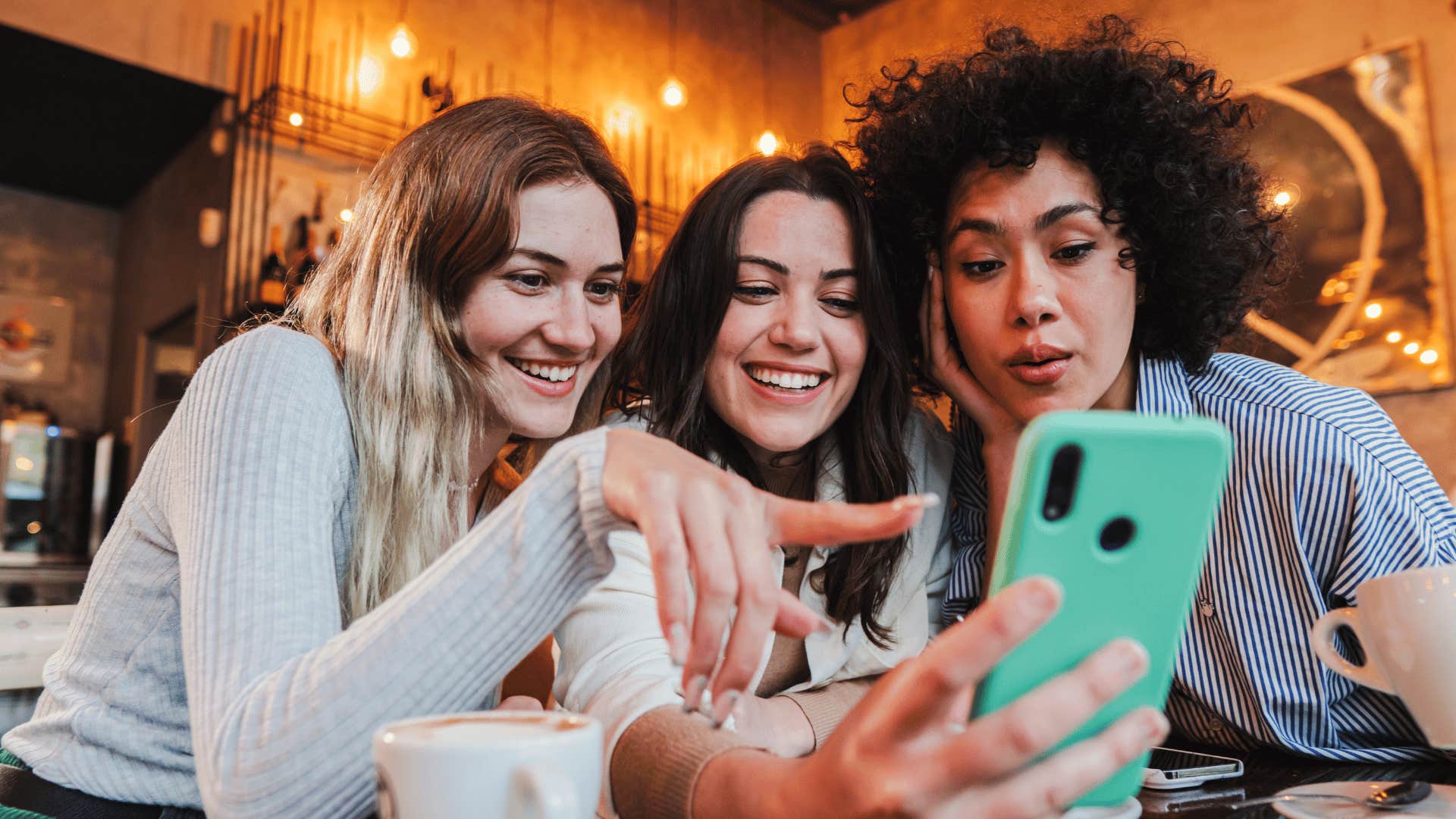 three female friends looking at a phone