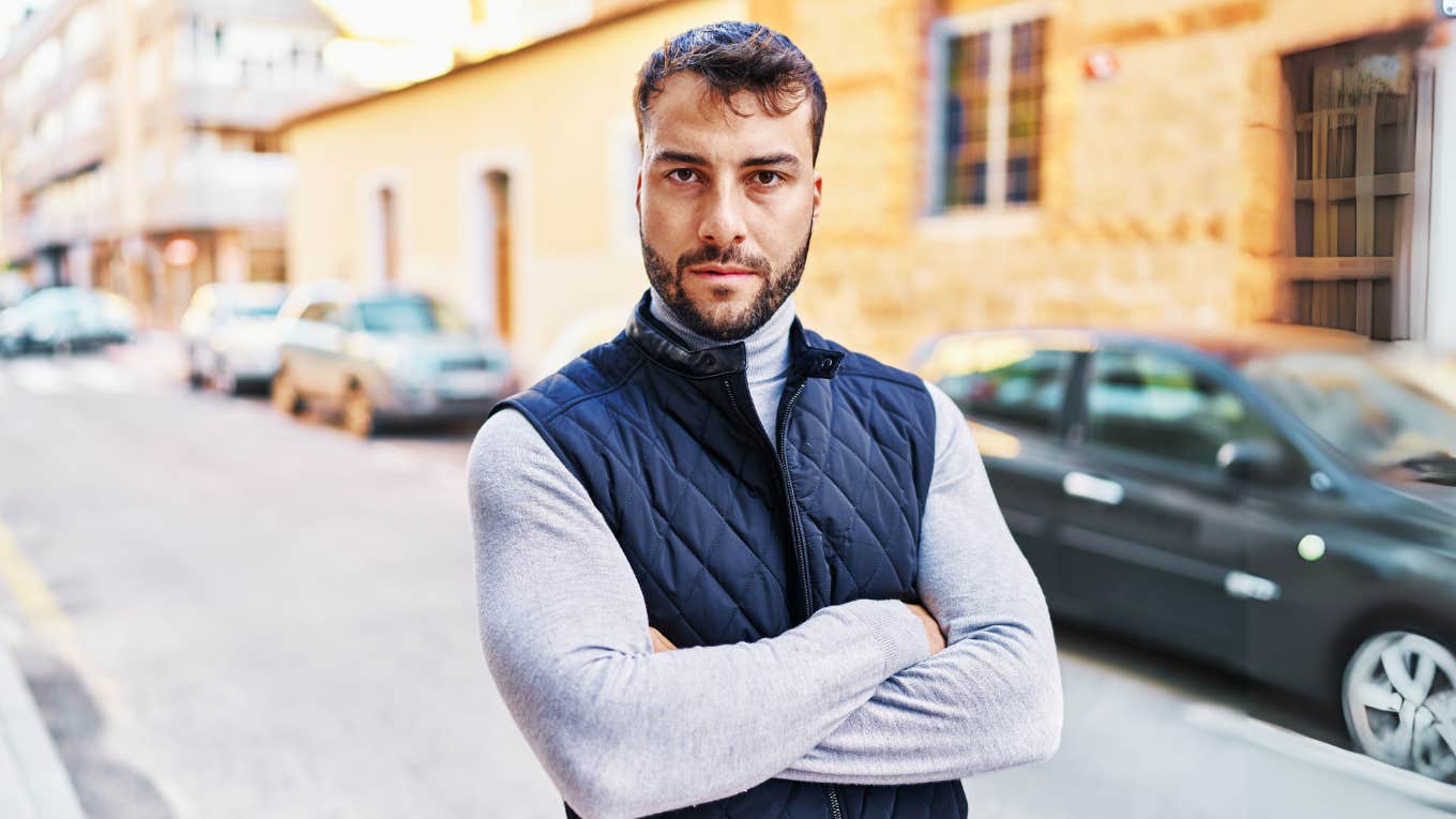 Narcissistic Man with arms crossed in street.