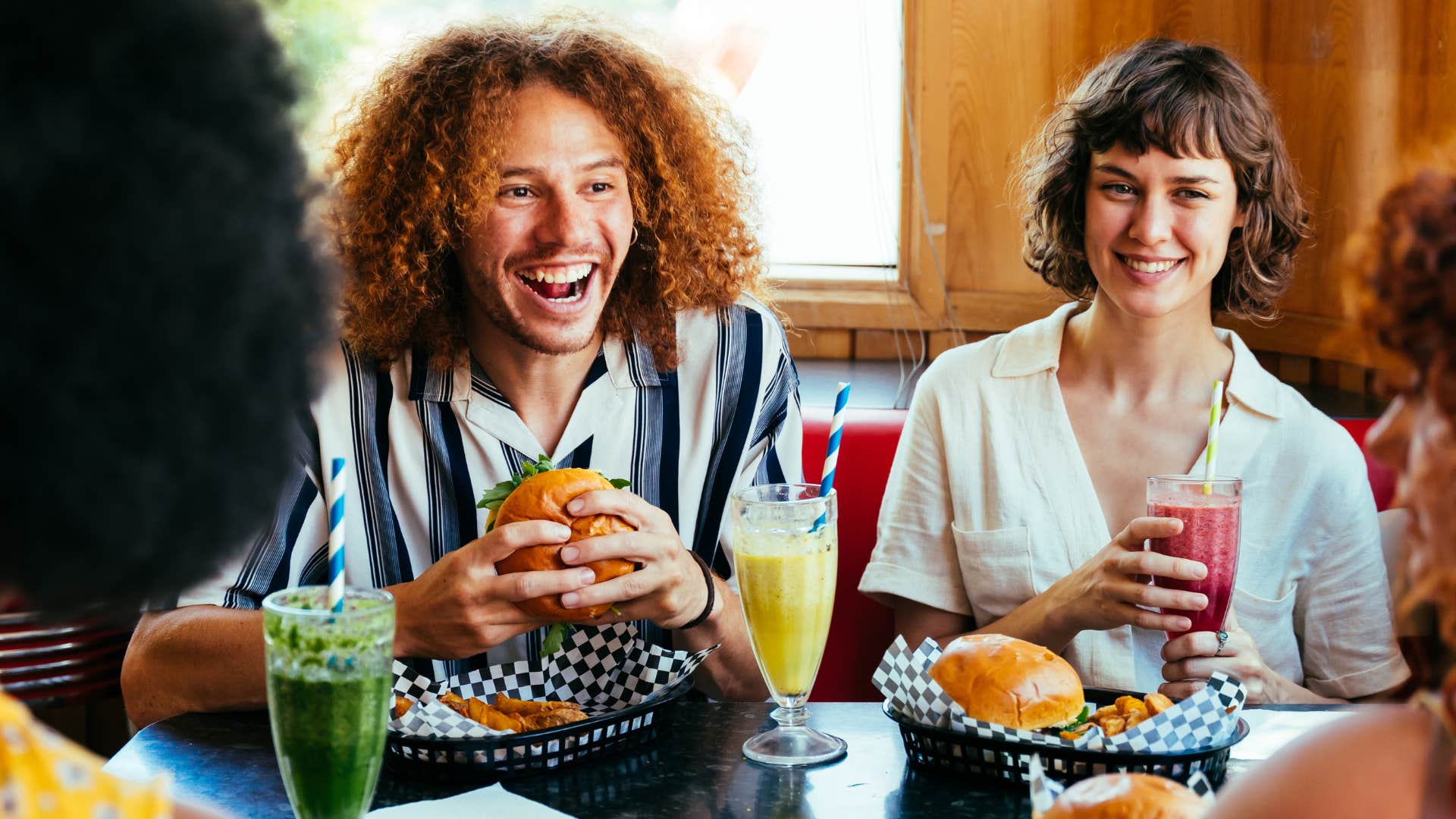 Friends smiling and eating a diner together