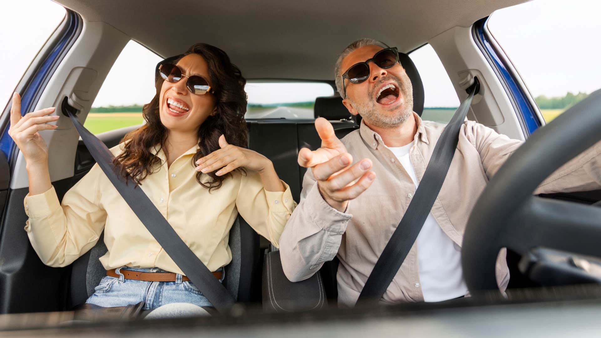 Couple smiling and singing in their car