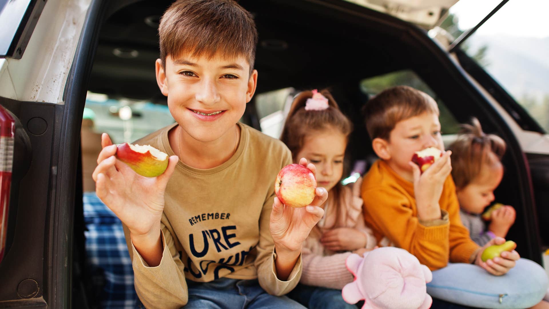 Kids smiling and eating an apple