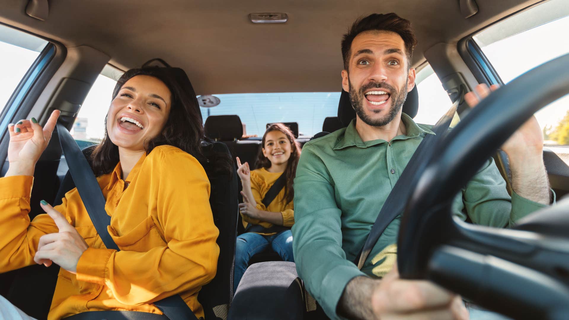 Family smiling and singing together in the car