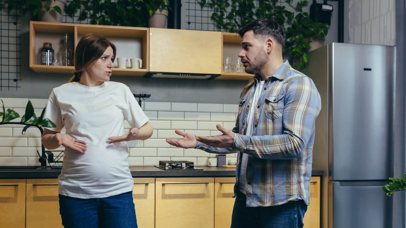 pregnant woman and man arguing in kitchen 