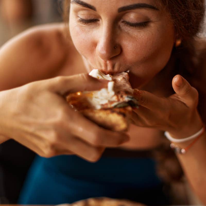 close up shot of woman eating pizza