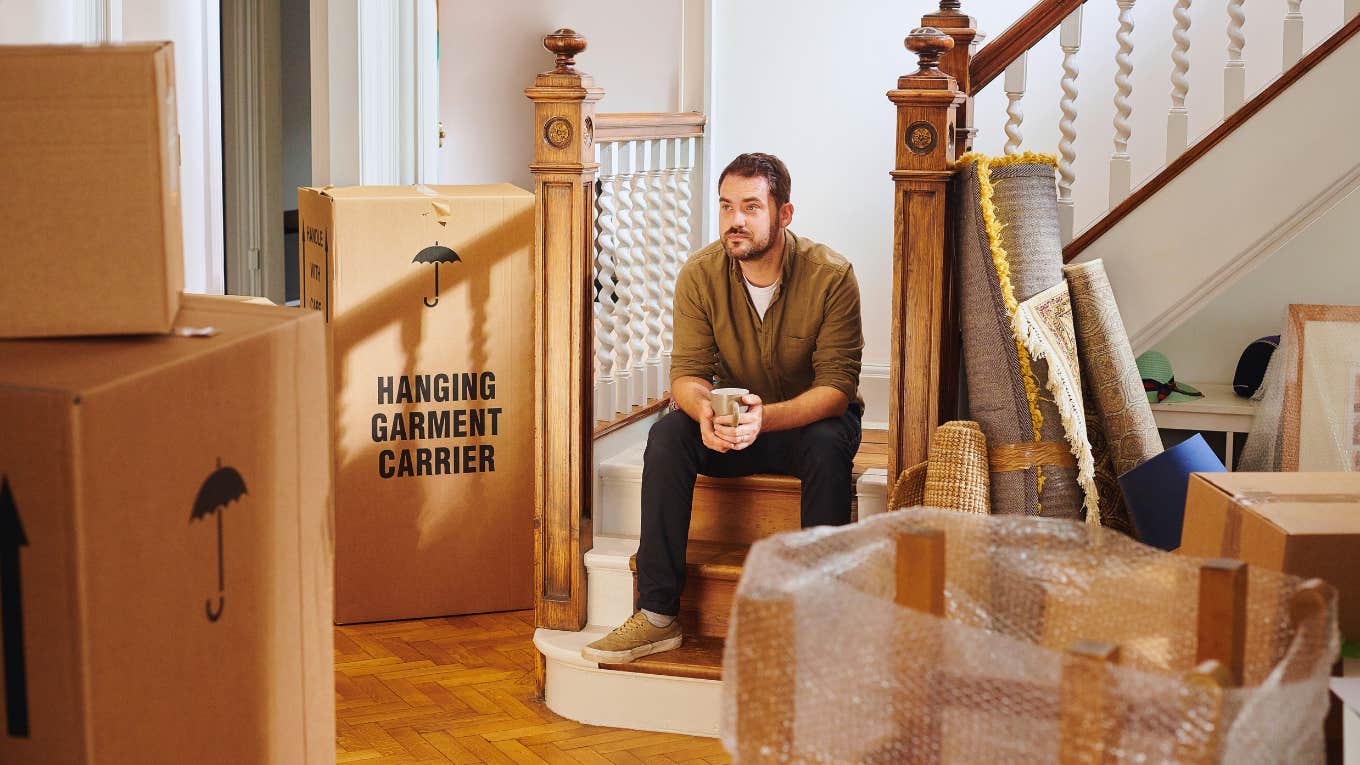 Man preparing to move out with packed boxes all around him