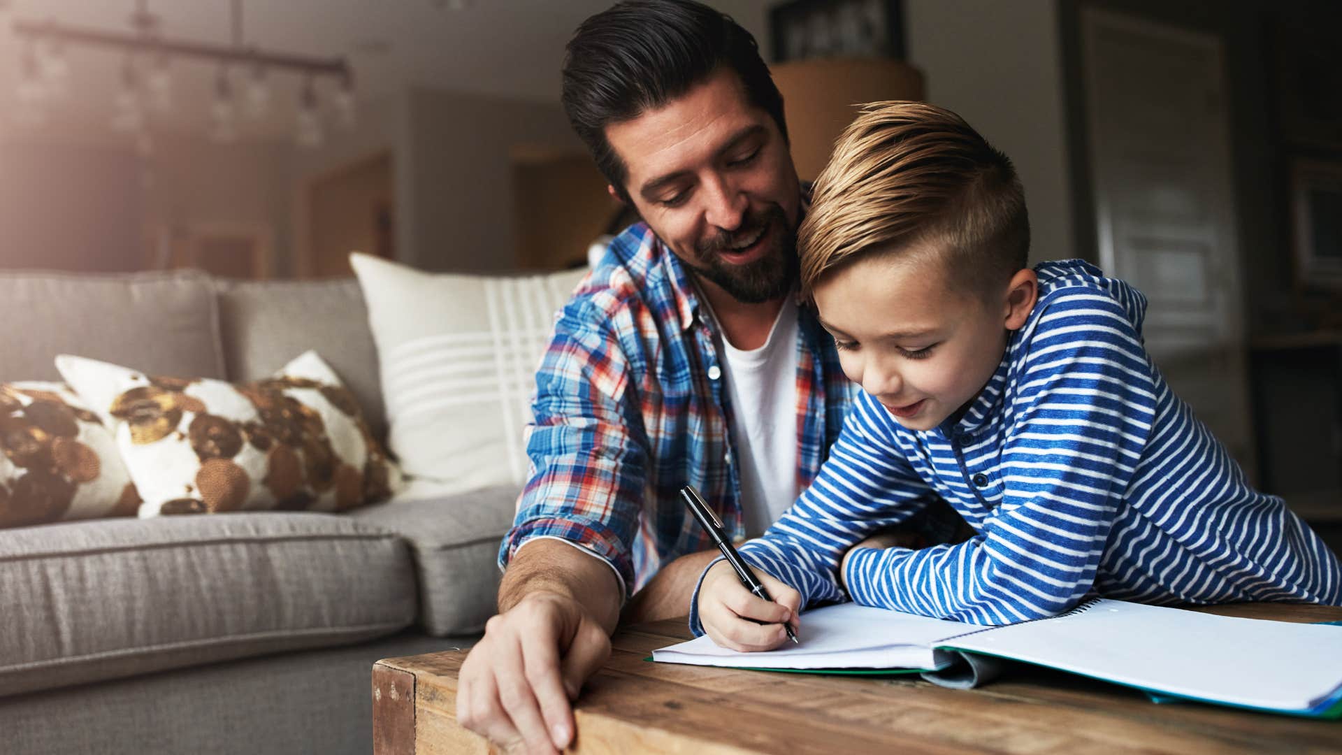 Young dad helping his son with homework.