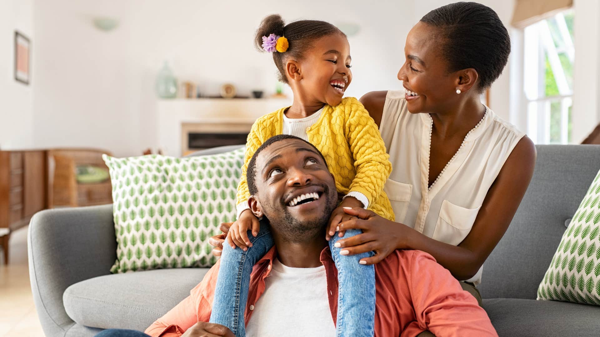 Smiling family hugging each other and sitting on the floor.