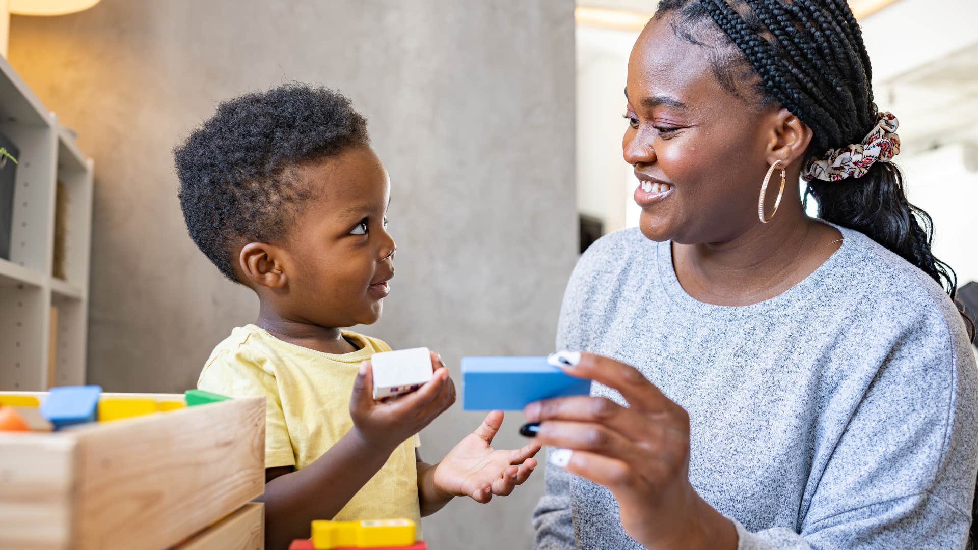 Mom smiling while playing with her son.