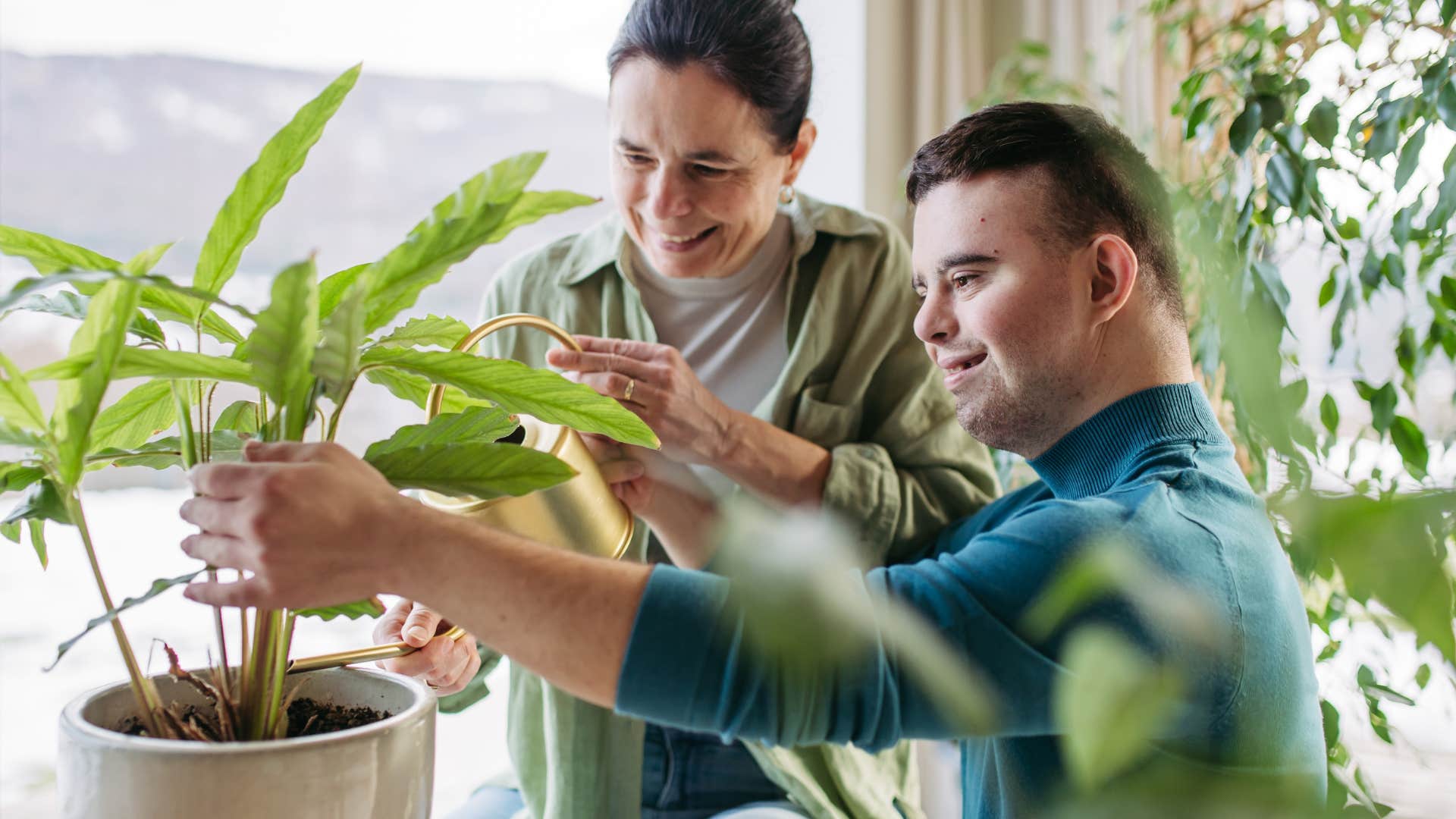 Mother and son tending to a plant together.