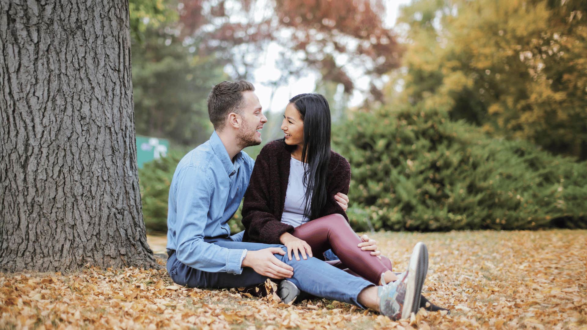 couple sitting under a tree talking