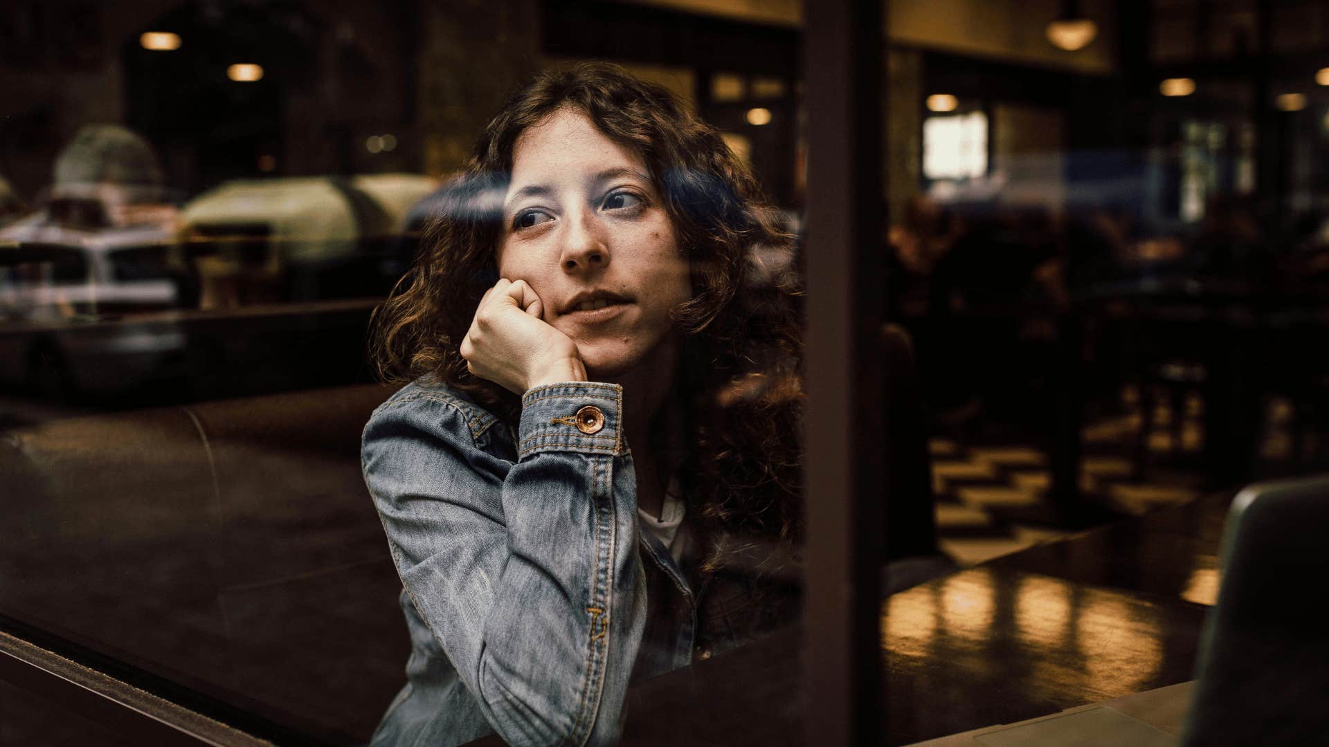 woman thinking while looking out a window