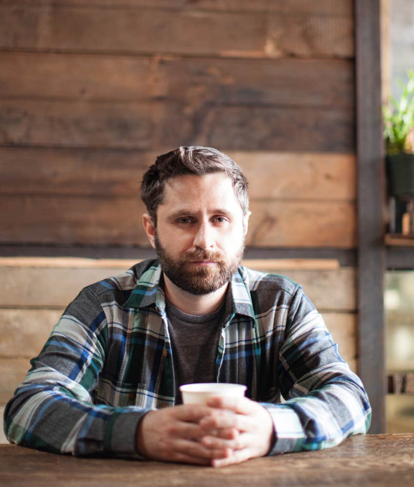 millennial man sitting in coffee shop looking serious