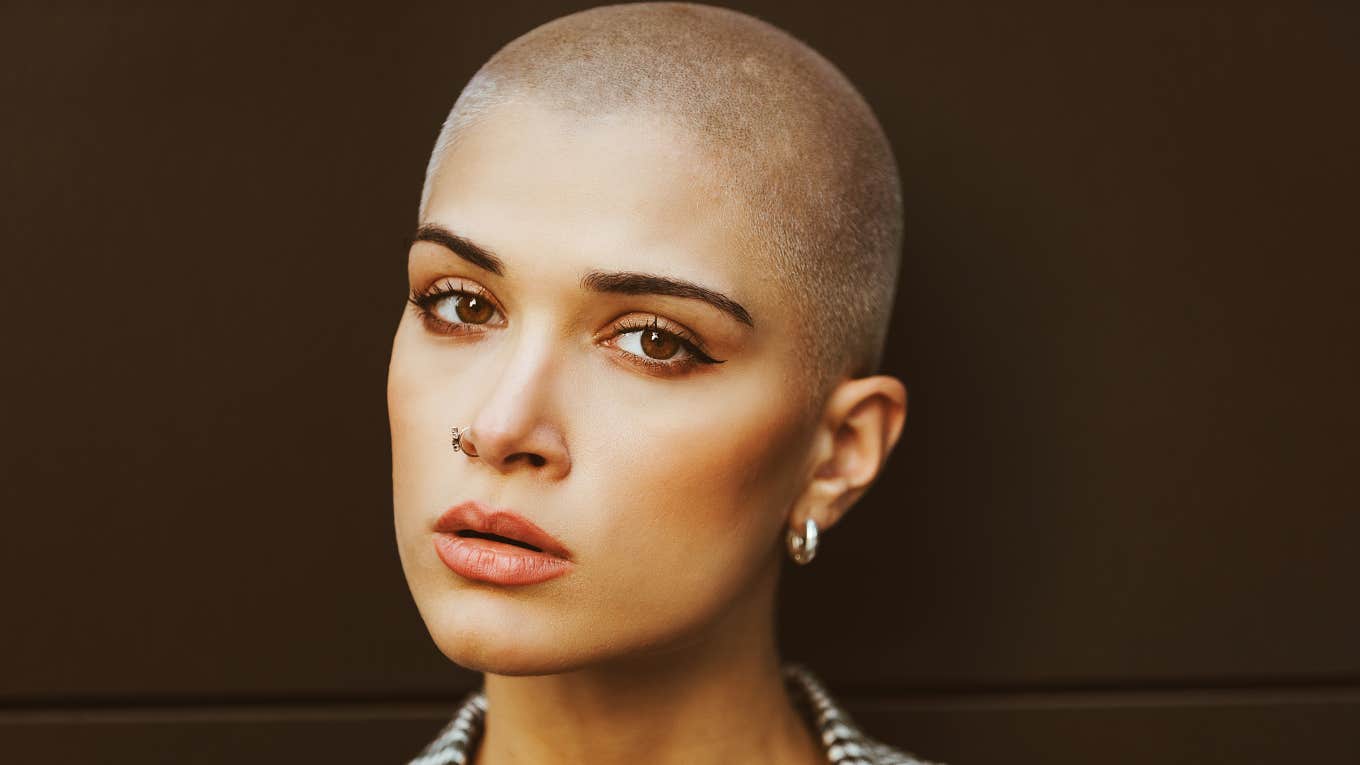 beautiful woman with shaved head looking serious